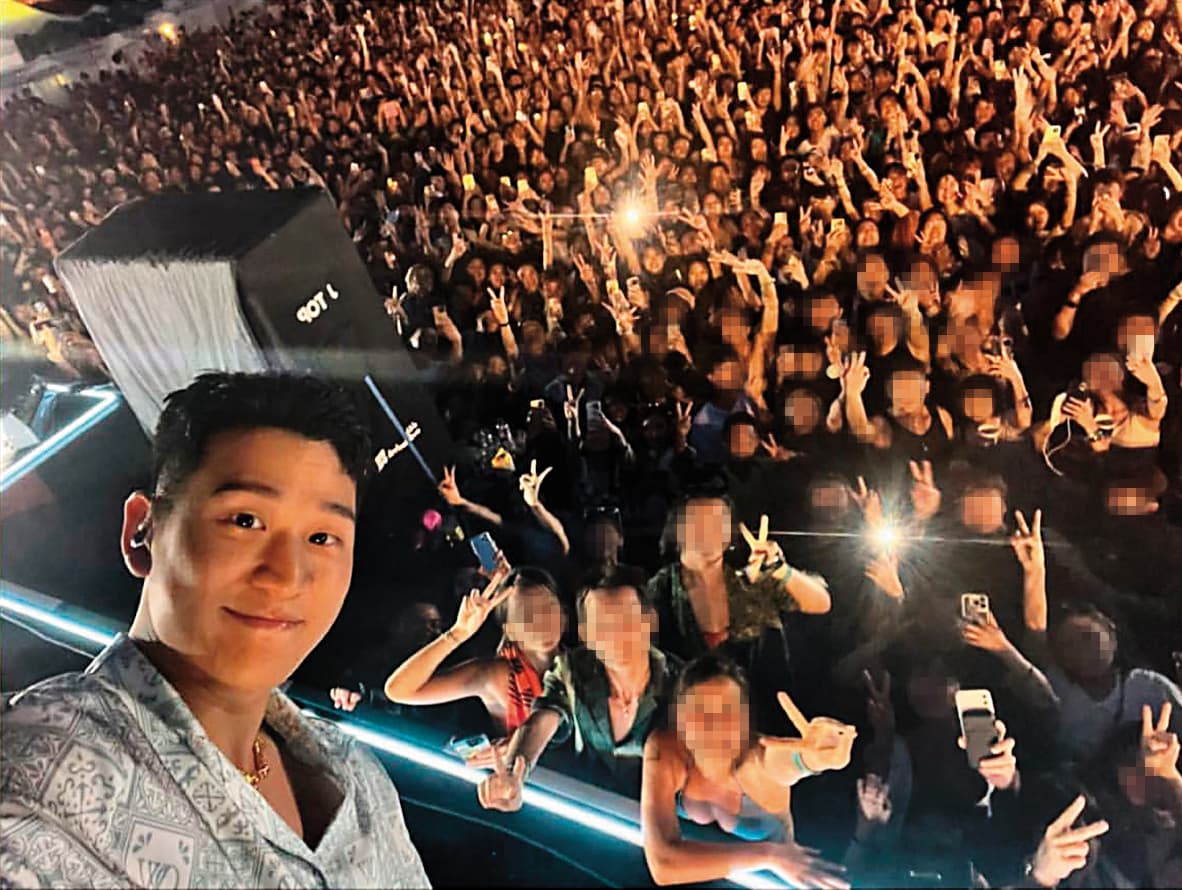 周興哲(左)現身香港愉景灣音樂節與粉絲自拍。你們不會都在注意右下角的比基尼辣妹吧?(瞪)(翻攝自周興哲IG)
