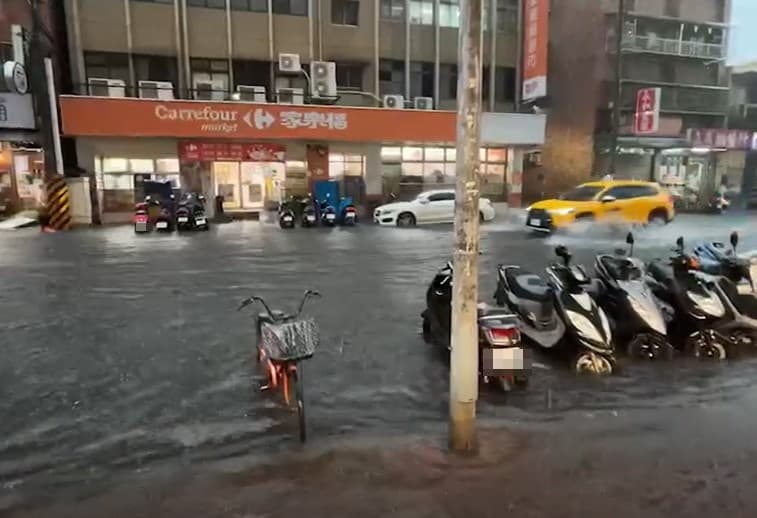 新北三重仁愛街淹水,積水高度已快淹沒路邊機車輪胎。(翻攝自記者爆料網)