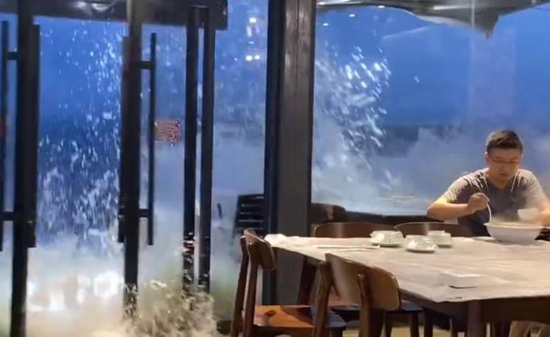 民眾在潿洲島海景餐廳用餐,突然間有道巨浪撞開大門。(翻攝微博)