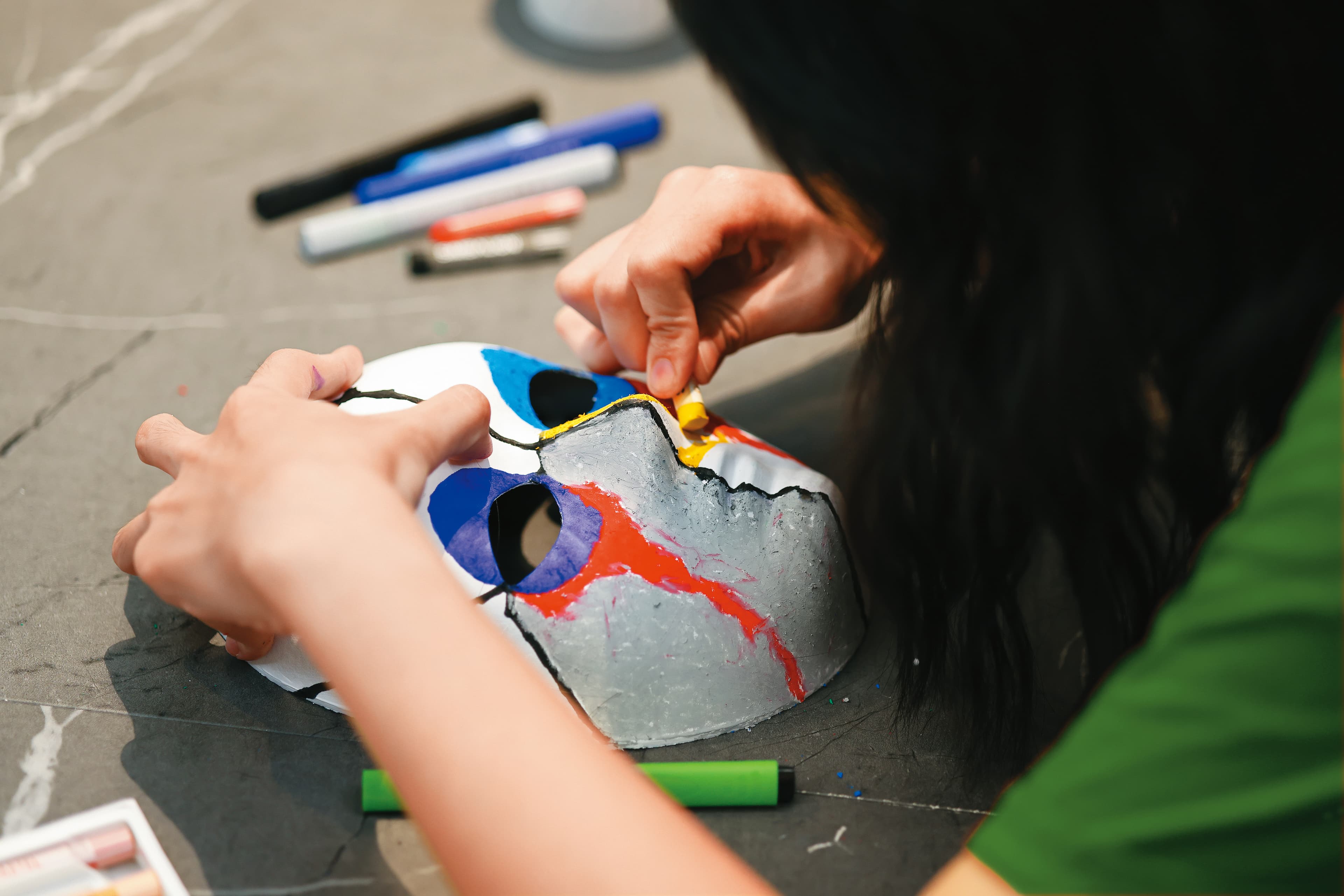 長達40分鐘,小云細心繪製面具,雙手沾滿蠟筆粉末。