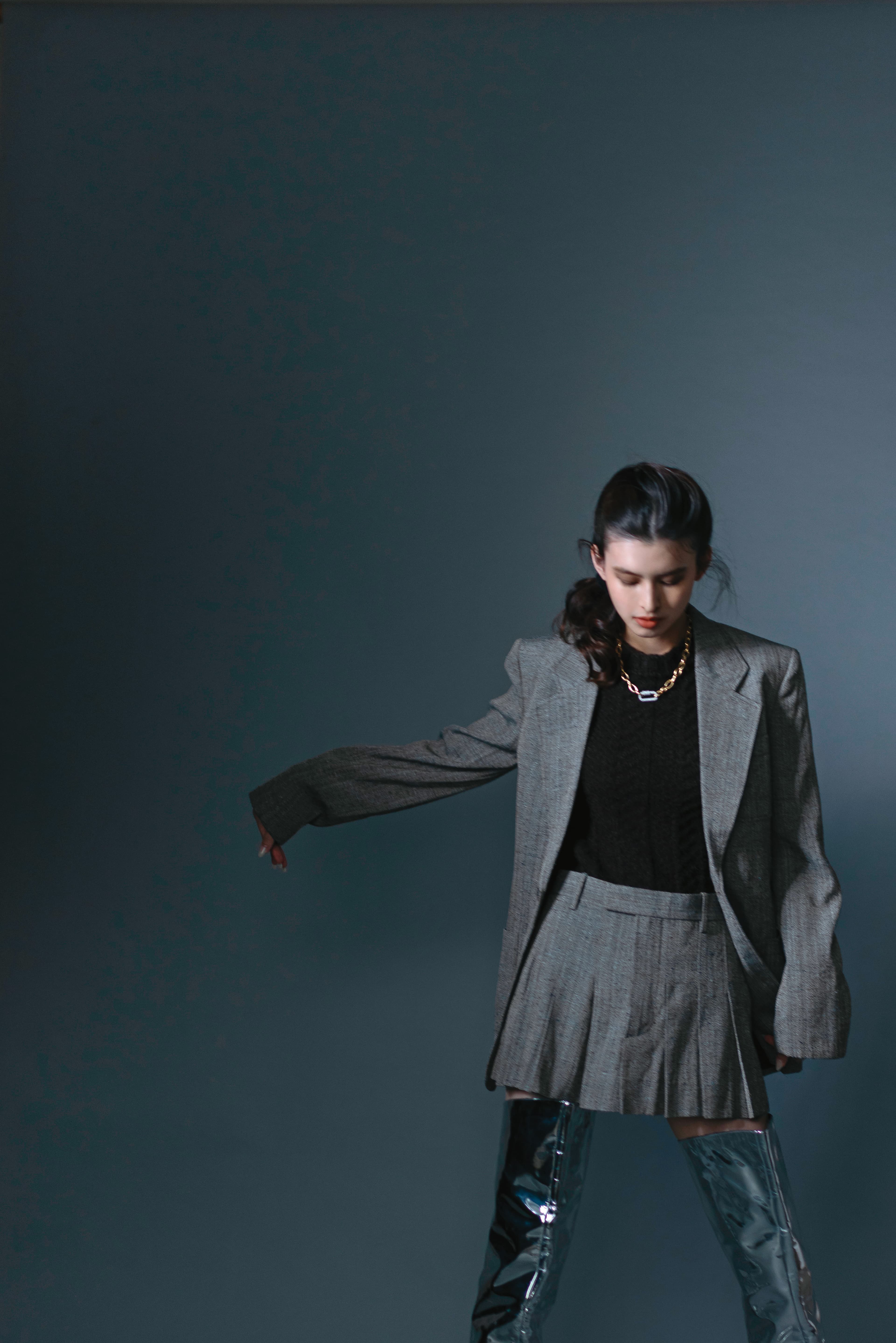 灰色紋理西裝，NT$91,600，by BOTTEGA VENETA；棕色針織毛衣，NT$47,900，by BOTTEGA VENETA；灰色紋理短裙，NT$47,900，by BOTTEGA VENETA；銀色過膝長靴，價格店洽，by BOTTEGA VENETA；密鑲鍊環項鍊，NT$10,000，by APM MONACO。