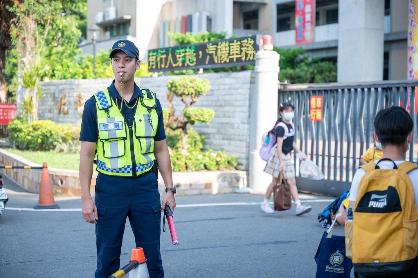 「天菜帥警」站校門守護學童,網友表示:「看到帥警察,媽媽我都想去上課了」。(翻攝自TCPB局長室臉書)