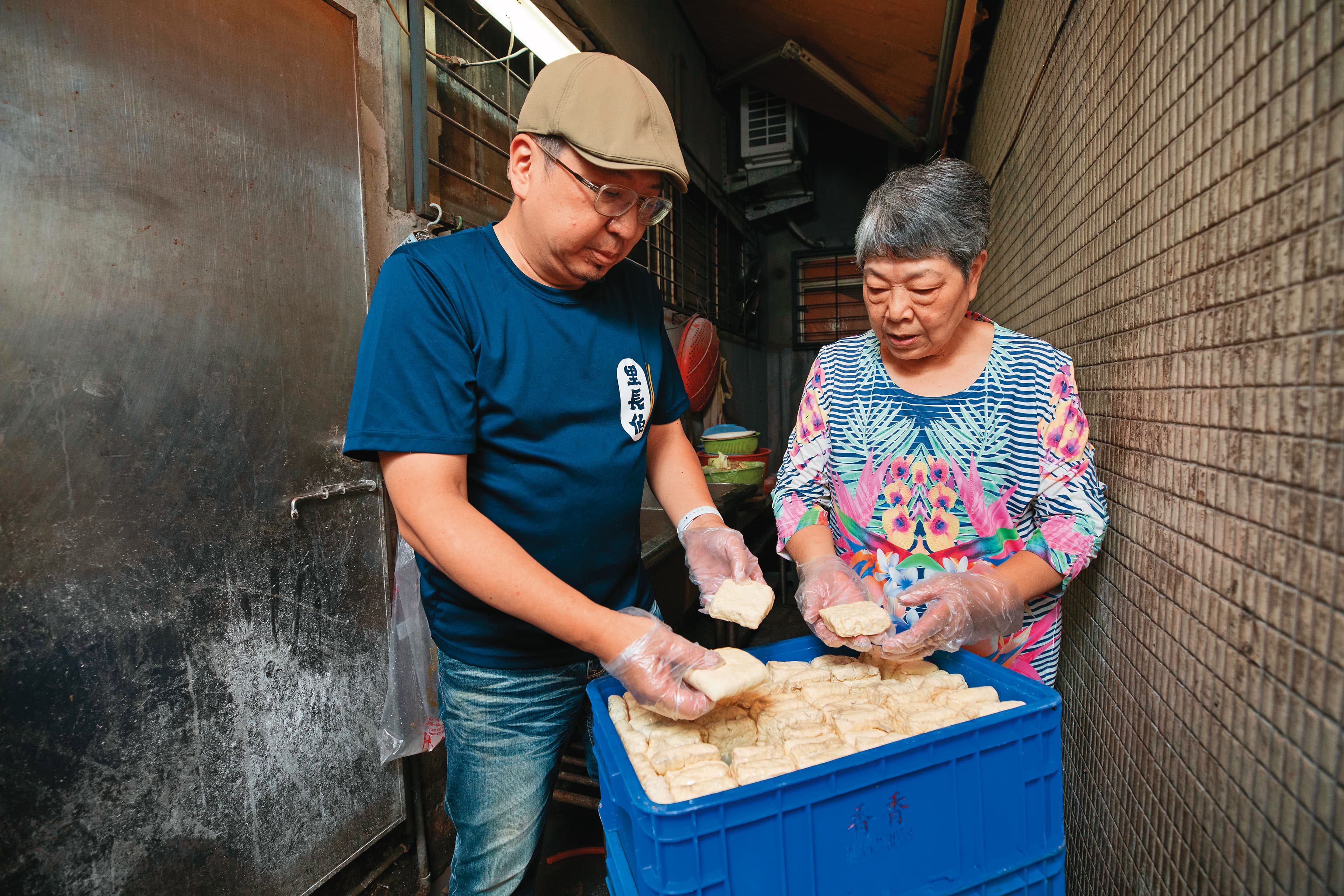 方寶銀(右)將家傳料理的祕訣傳給兒子李啟榮(左),老店至今都選用成本較高的非基改黃豆做臭豆腐。