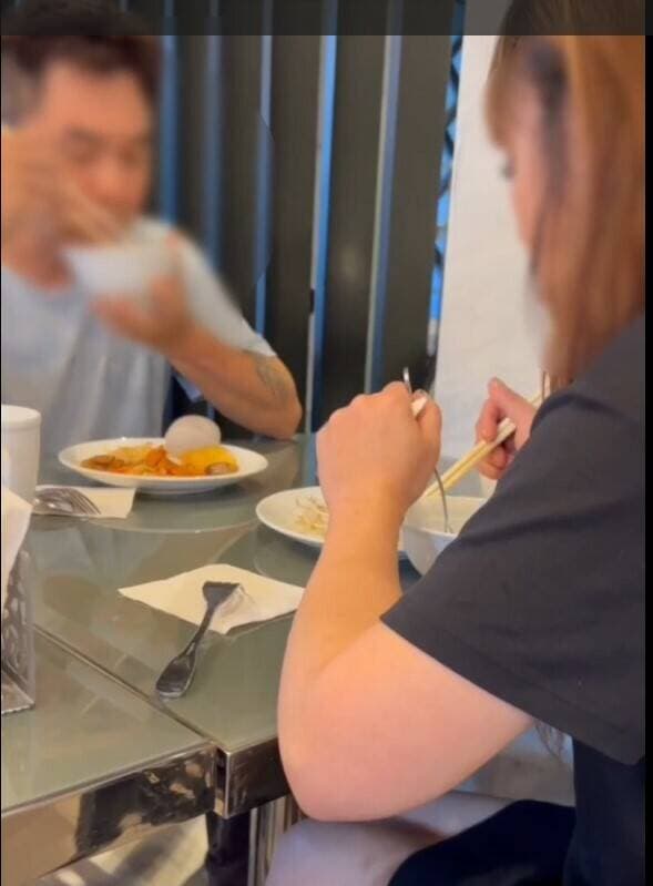 警察拘捕時,洪男與女友悠閒繼續吃早餐,一臉不甩警察的神情。(翻攝畫面)