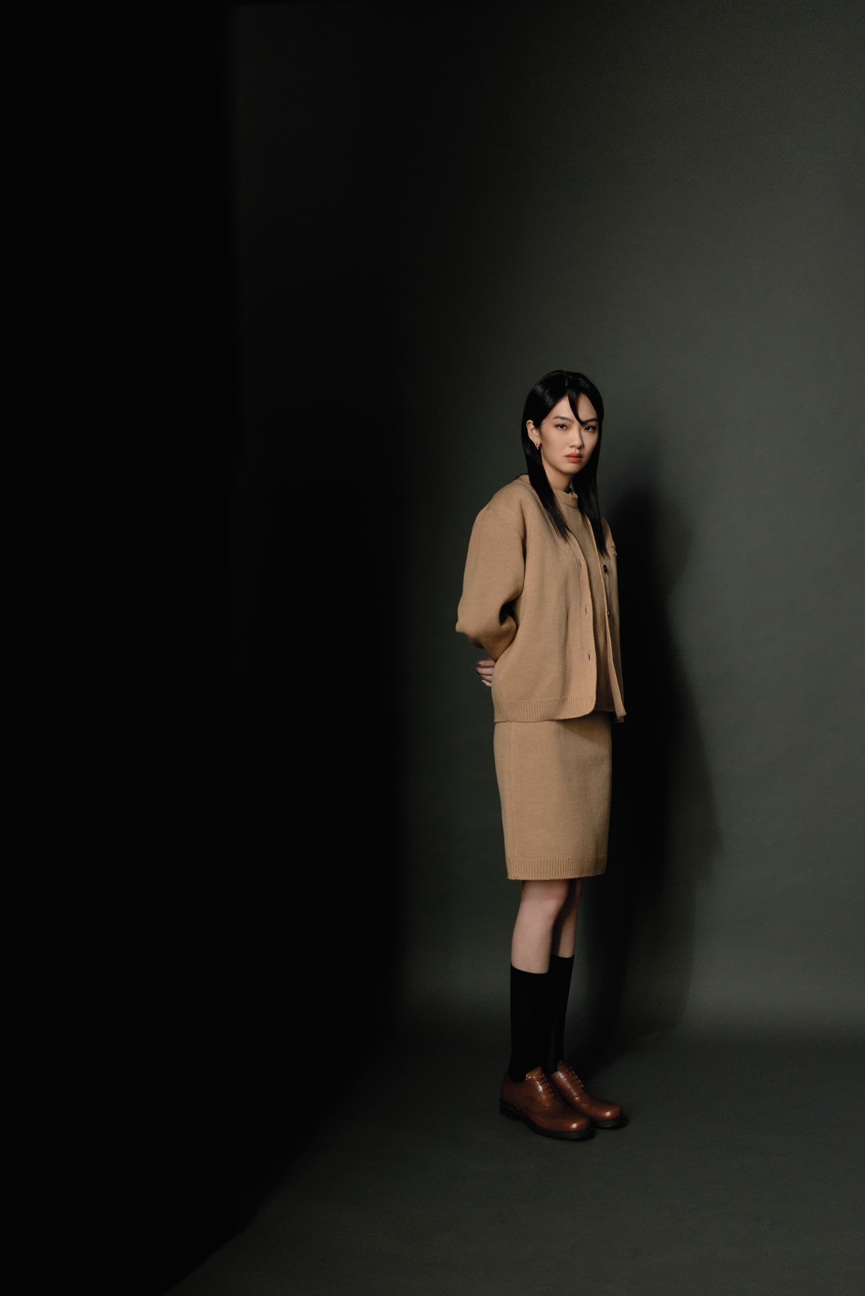 咖啡色羊毛開襟衫 NT$95,000 by MIU MIU／咖啡色羊毛衫 價格店洽by MIU MIU／餅乾色羊毛及膝裙 價格店洽by MIU MIU／DIOR BEE黑色CD與蜜蜂刺繡羊毛長襪 NT$16,000 by DIOR／牛津雕花鞋 NT$40,000 by Church's X MIU MIU／Moonlight Grapes系列18K黃金鑽石（0.13CT）耳環 NT$87,000 by GEORG JENSEN