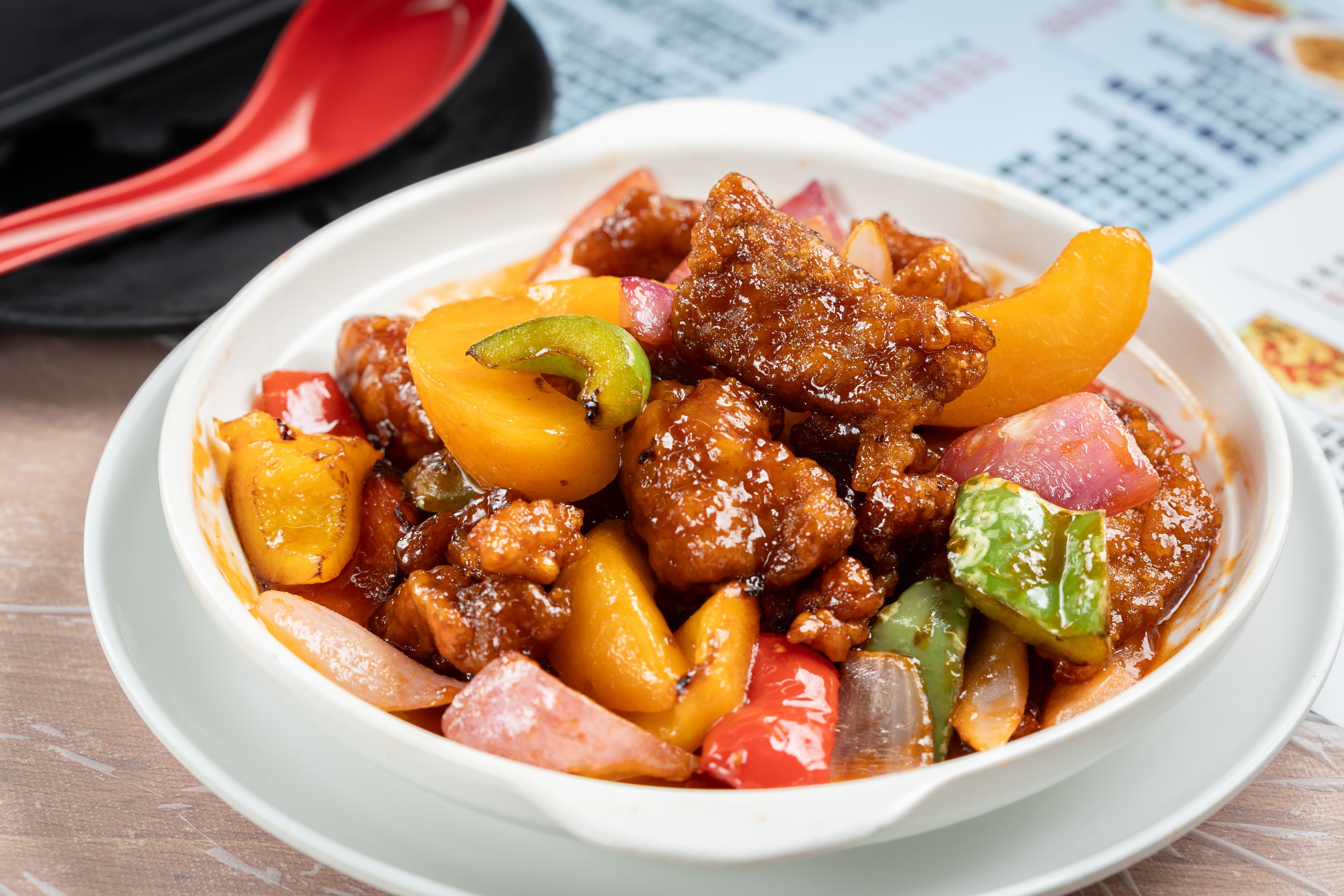 「蜜桃拔絲真咕咾肉」將酥炸豬肉塊裹上酸甜醬汁,並改以蜜桃入饌,清新解膩。(港幣88元/份,約NT$336)