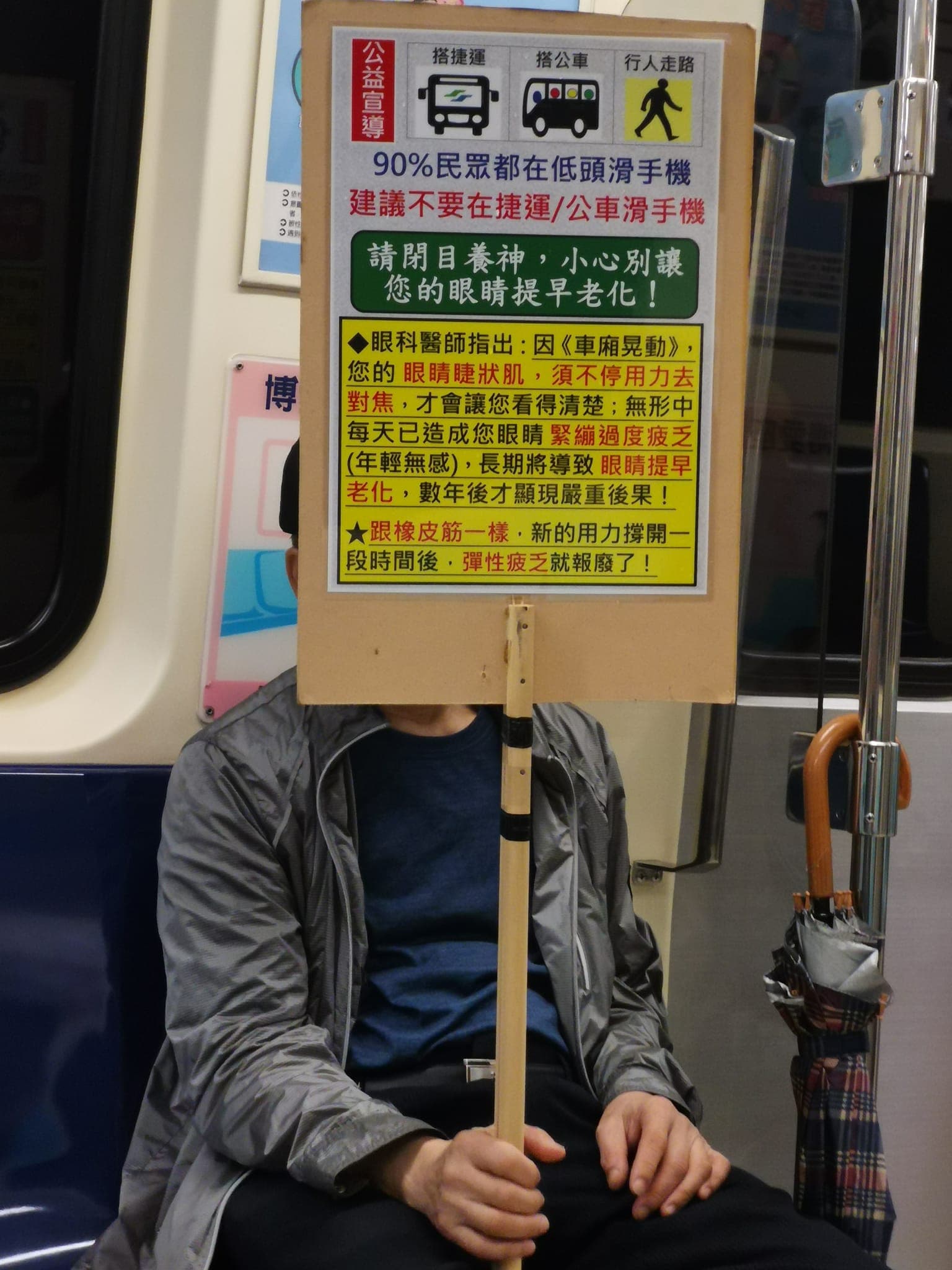 有位坐在博愛座的阿北手舉立牌,提醒大家不要在捷運或公車上滑手機。(翻攝自路上觀察學院)