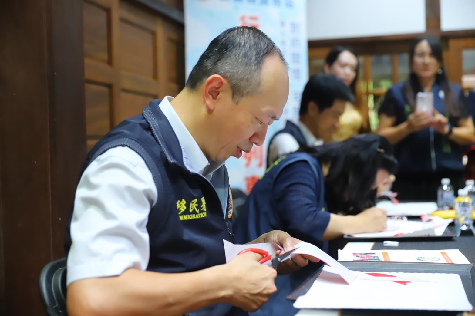 移民署謝文忠主任祕書訪視嘉義縣青翼文化產業協會,體驗剪紙藝術。(移民署提供)