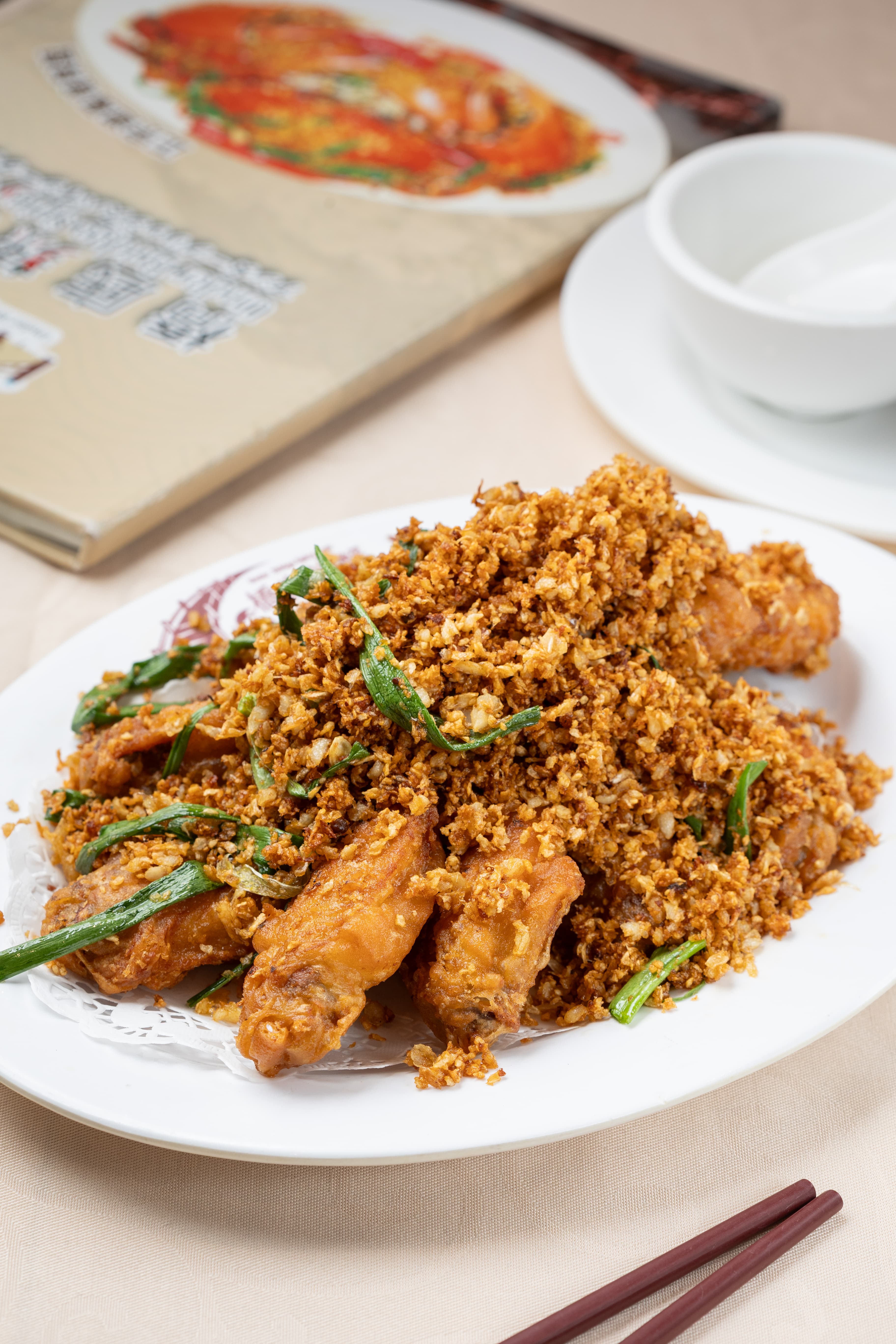 「避風塘雞中翼」染上蒜酥香氣,啃起來十分夠味。(港幣88元/份,約NT$331)