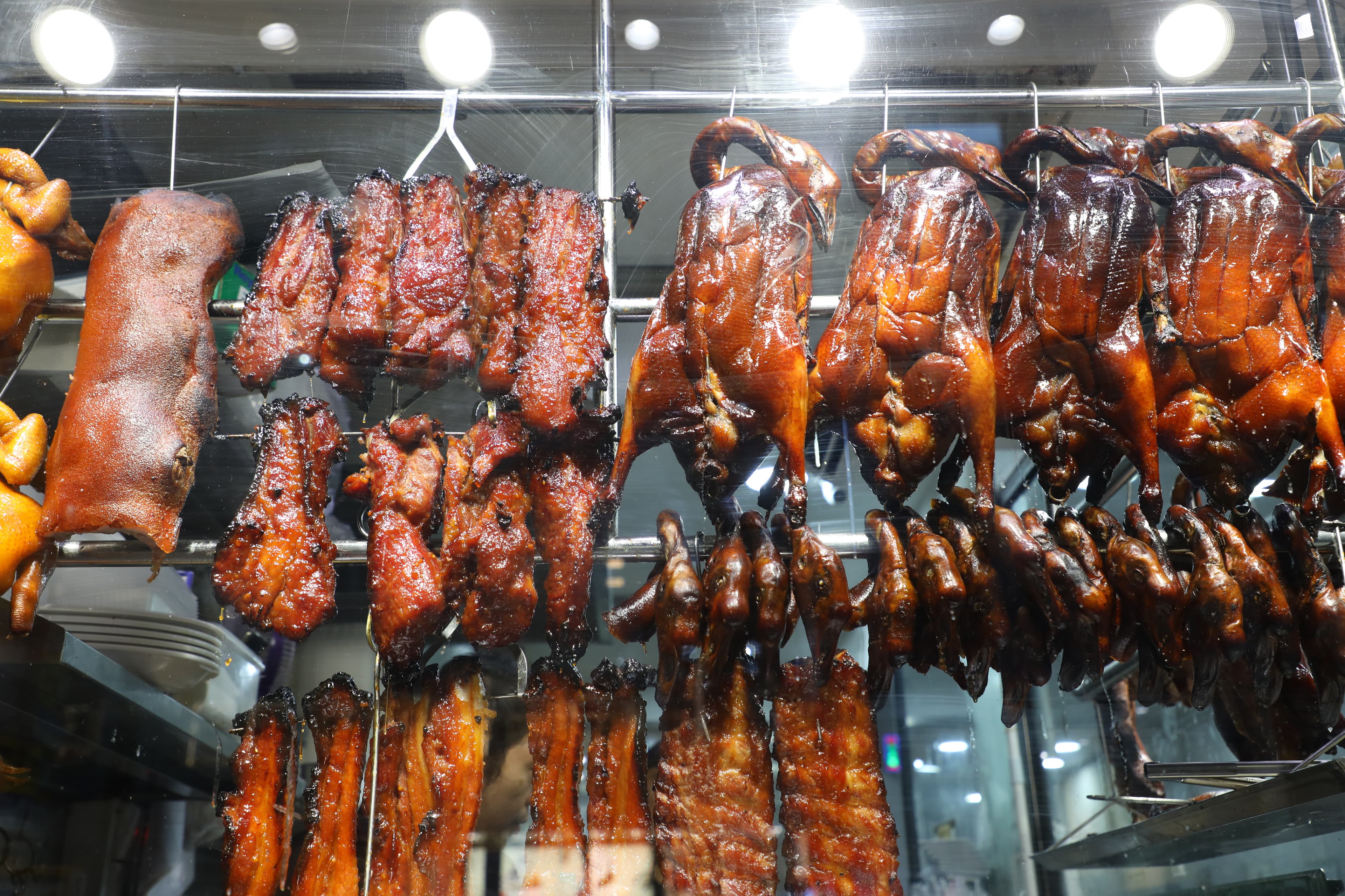櫥窗吊掛著品類豐富的燒味，燒鵝、叉燒、乳豬，每一樣都令人垂涎。