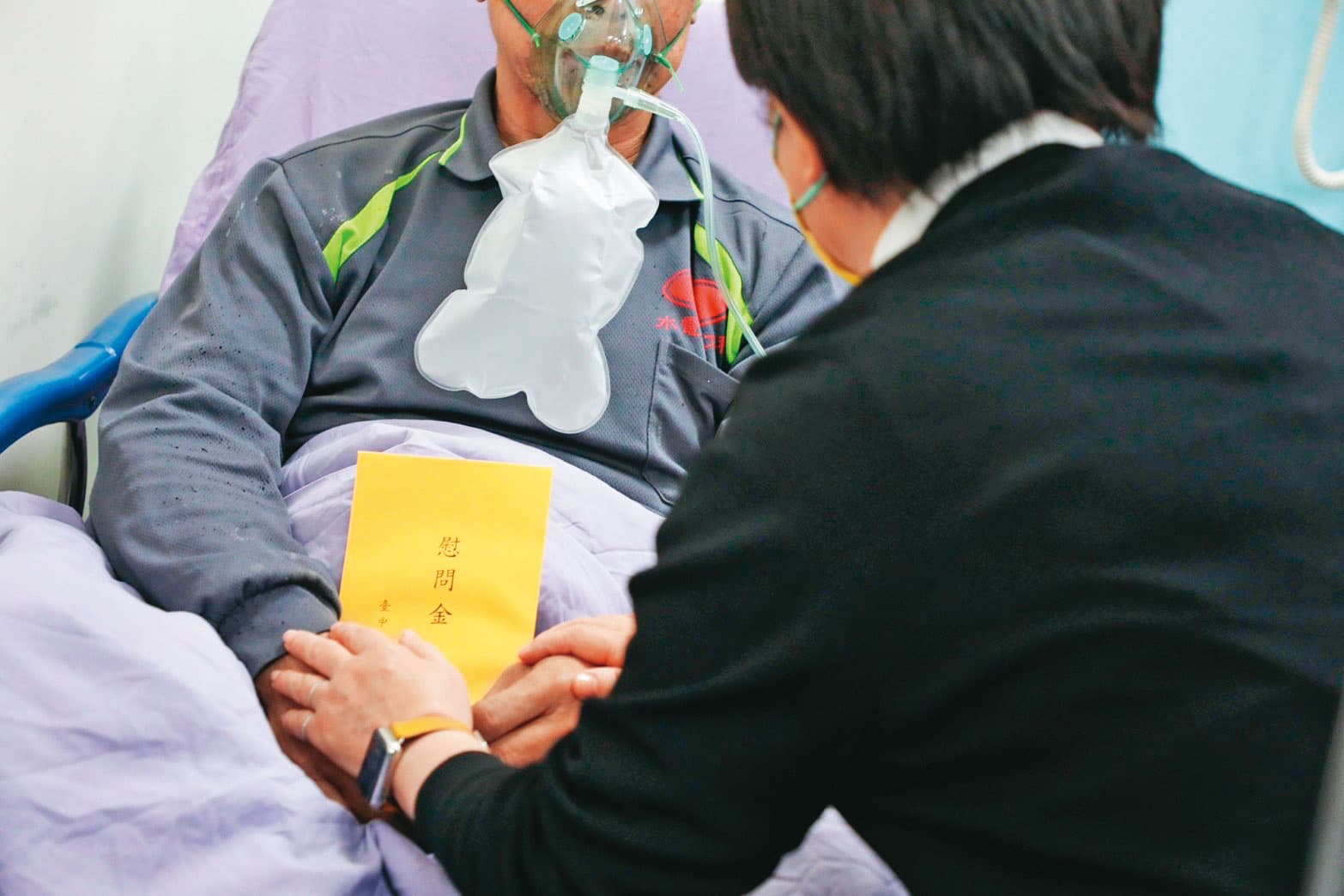 台中市長盧秀燕(右)到醫院探視火災傷者(左),並發送慰問金。(翻攝台中市政府官網)