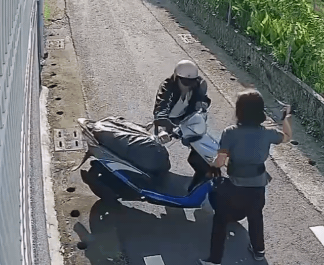 婦人撿回包包後拿起背帶對歹徒「鞭數十」,歹徒狼狽騎車逃跑。(翻攝畫面)