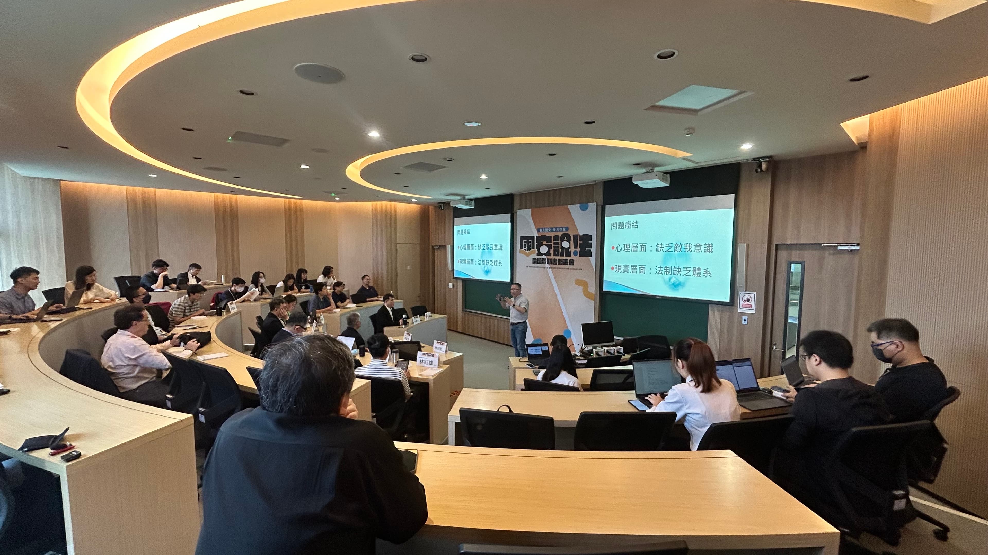 身兼臺大法律學院教授的政務委員林明昕以自己擔任公職1年來的經驗，發表演講，說明現階段儘速建立我國國安法制的必要性與困難度。（民間國家安全與民主韌性法制研究群提供）