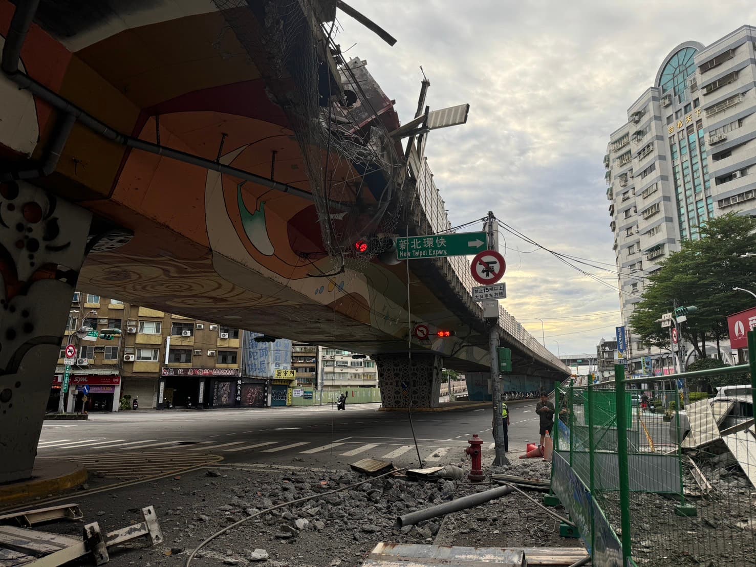 聯結車發生鋼筋掉落意外,也造成橋下方的平面道路因碎石、護欄等,讓整個交通一度大打結。(翻攝自侯友宜臉書)