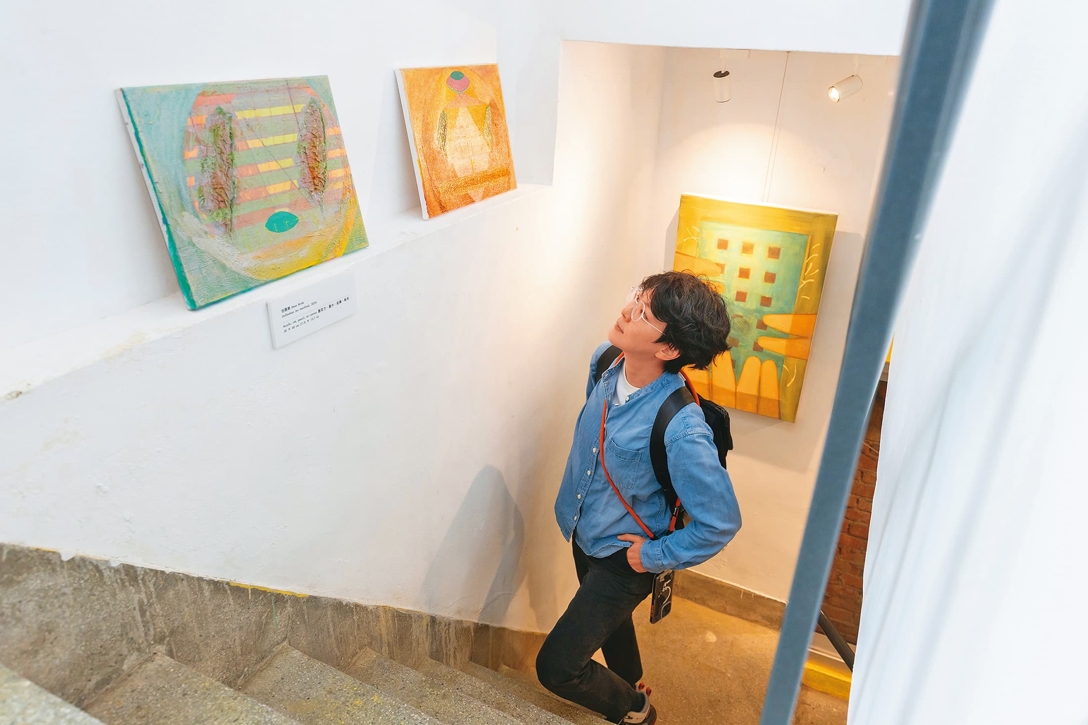 樓梯間邊牆上展示著陽明交大教授包德樂的畫作,宣揚他追求和平的理念。