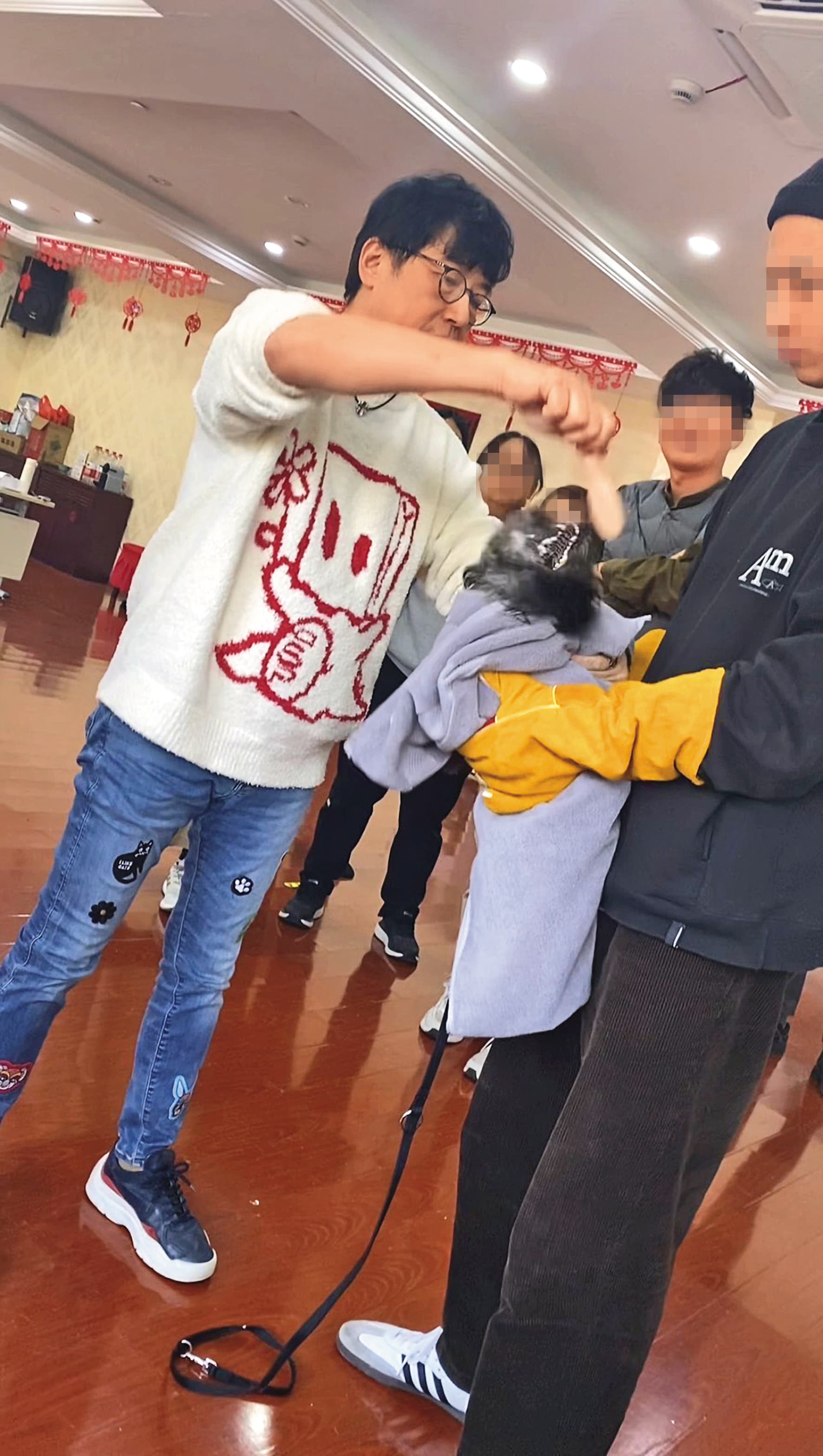 戴更基示範洪水法幫狗梳頭,讓狗嚇到咬梳子,導致狗嘴巴流血。(讀者提供)