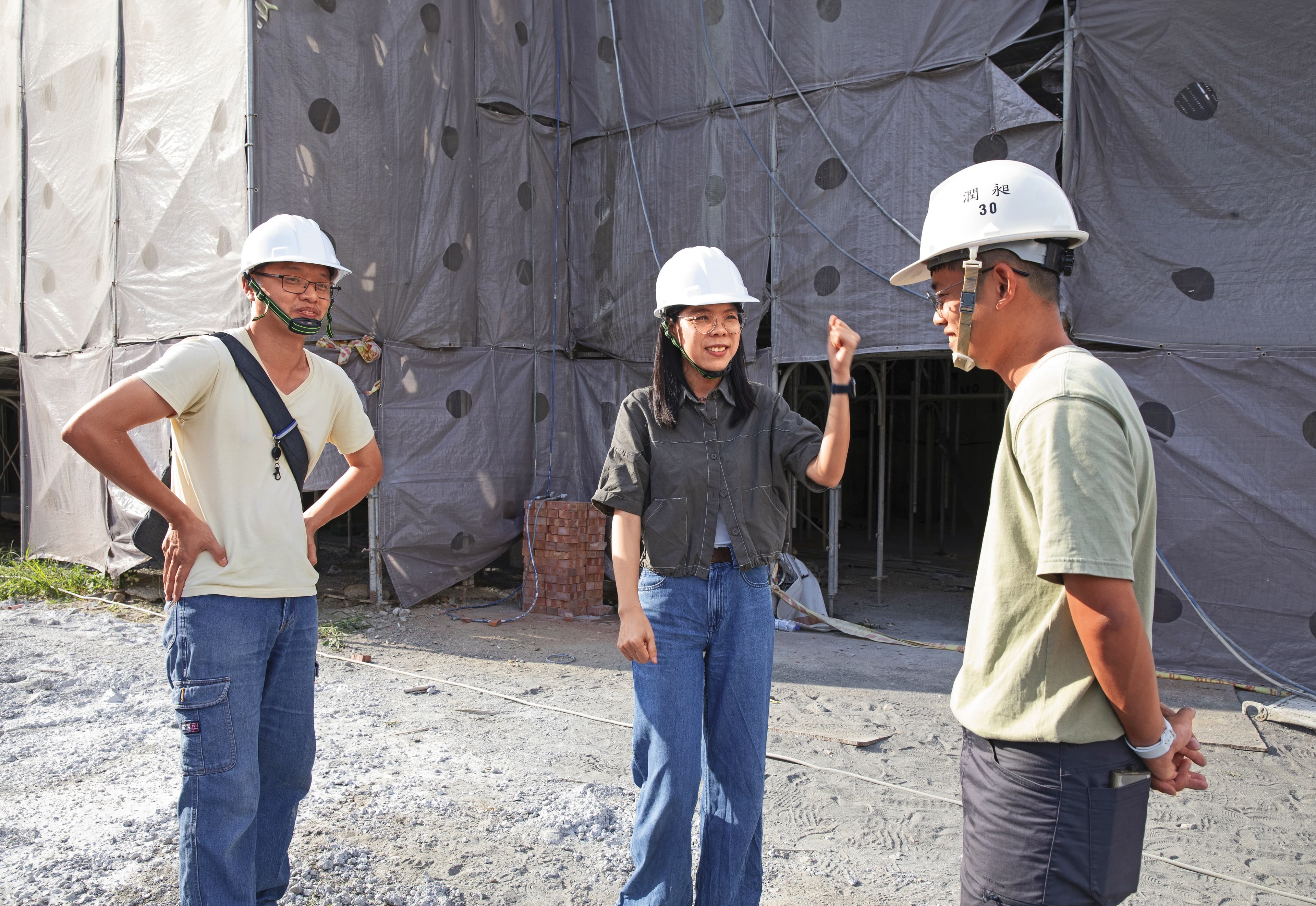 劉育育(中)與苑裡市場重建案工地主任聊天,關心歷史建築修復進度。