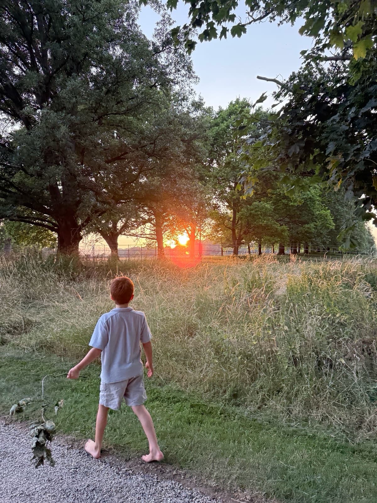 亞契光腳丫走在小徑裡，看夕陽，他看起來長高不少。（翻攝meghan IG）
