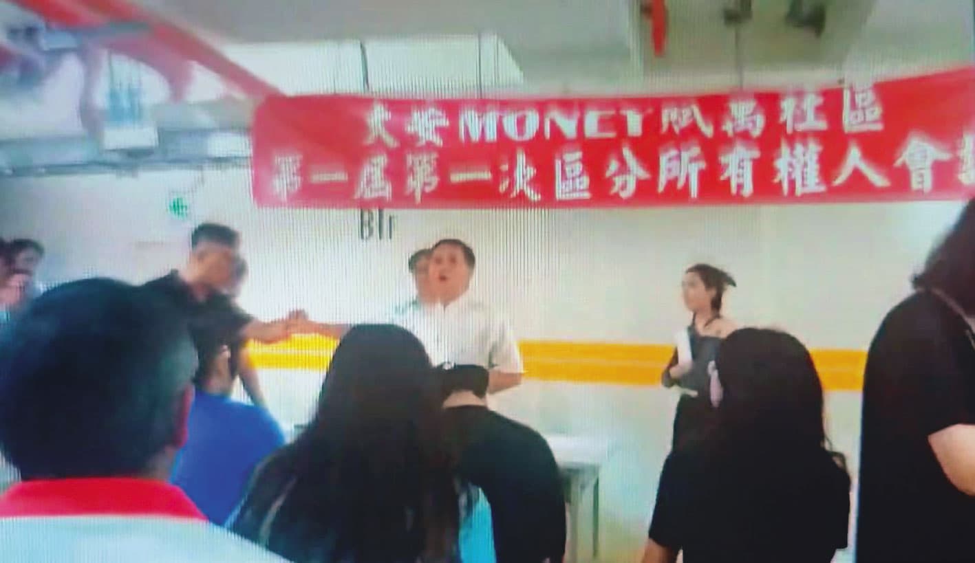 劉進明(白衣者)在區權會質疑公安問題,與恆合建設代表爆發口角、拉扯。(讀者提供)