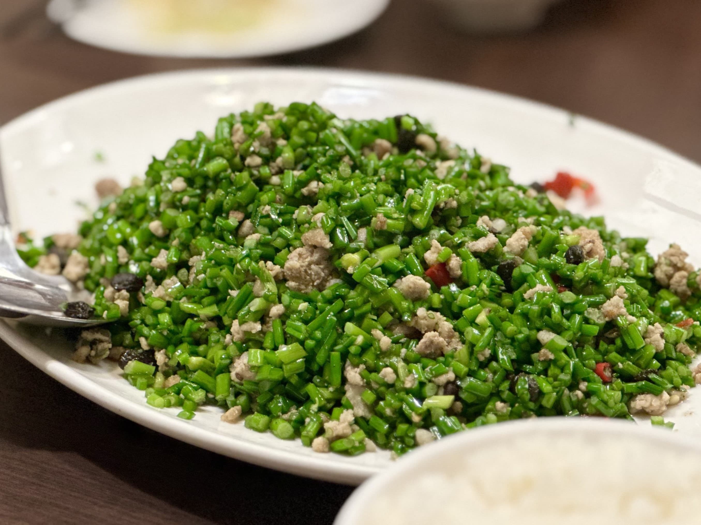 「蒼蠅頭」韭菜花口感細脆,配肉末、豆豉、辣椒一起吃,鹹香下飯。(240元/份)