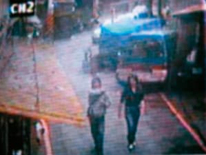 余男(左)與女友(右)犯案後走出養母家,2人有說有笑,十分冷血。(翻攝畫面)