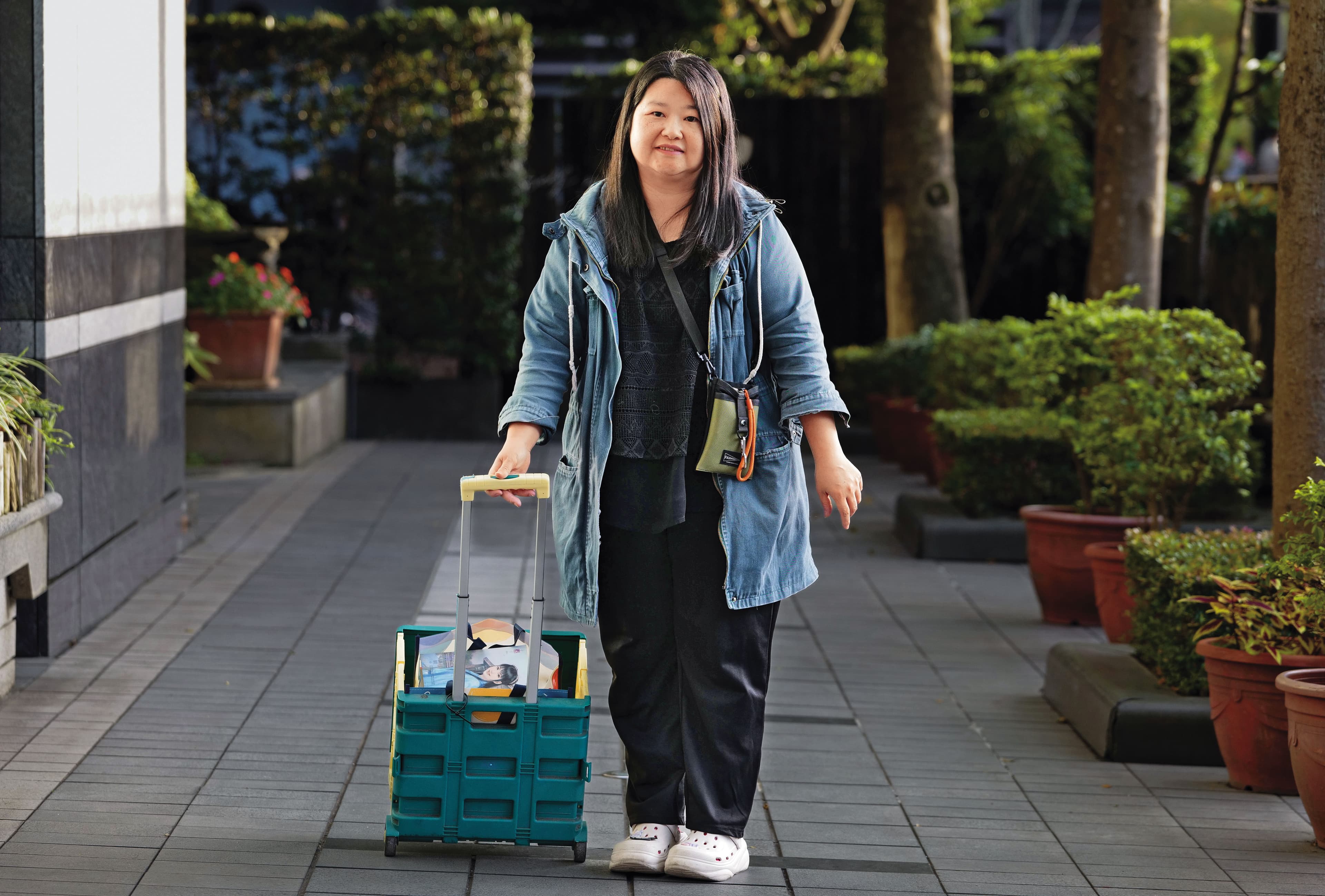 林彩蘋拉著小拖車受訪,裡面全是她珍藏的言情小說。(杭大鵬攝)