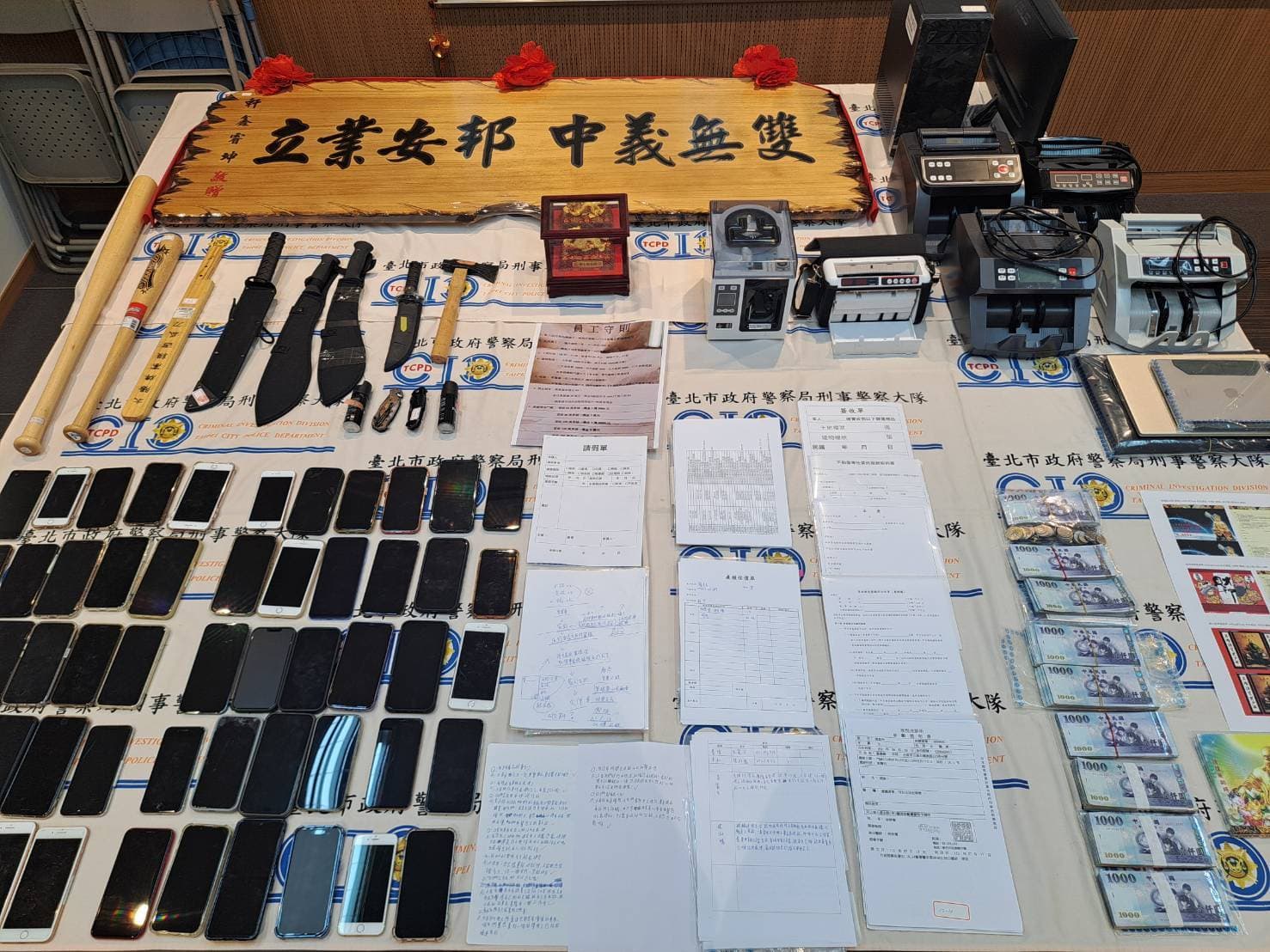 警方現場查扣現金74萬餘元、點鈔機、土地及建物謄本、行動電話等犯罪證物。(翻攝畫面)