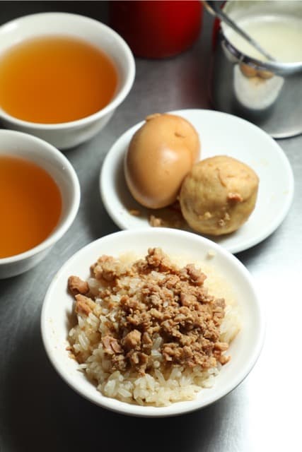 不需加醬就很美味的「米糕」（前，45元／份，附柴魚湯），在地人的標配是「滷蛋」（20元／顆）和「貢丸」（20元／顆）各一。