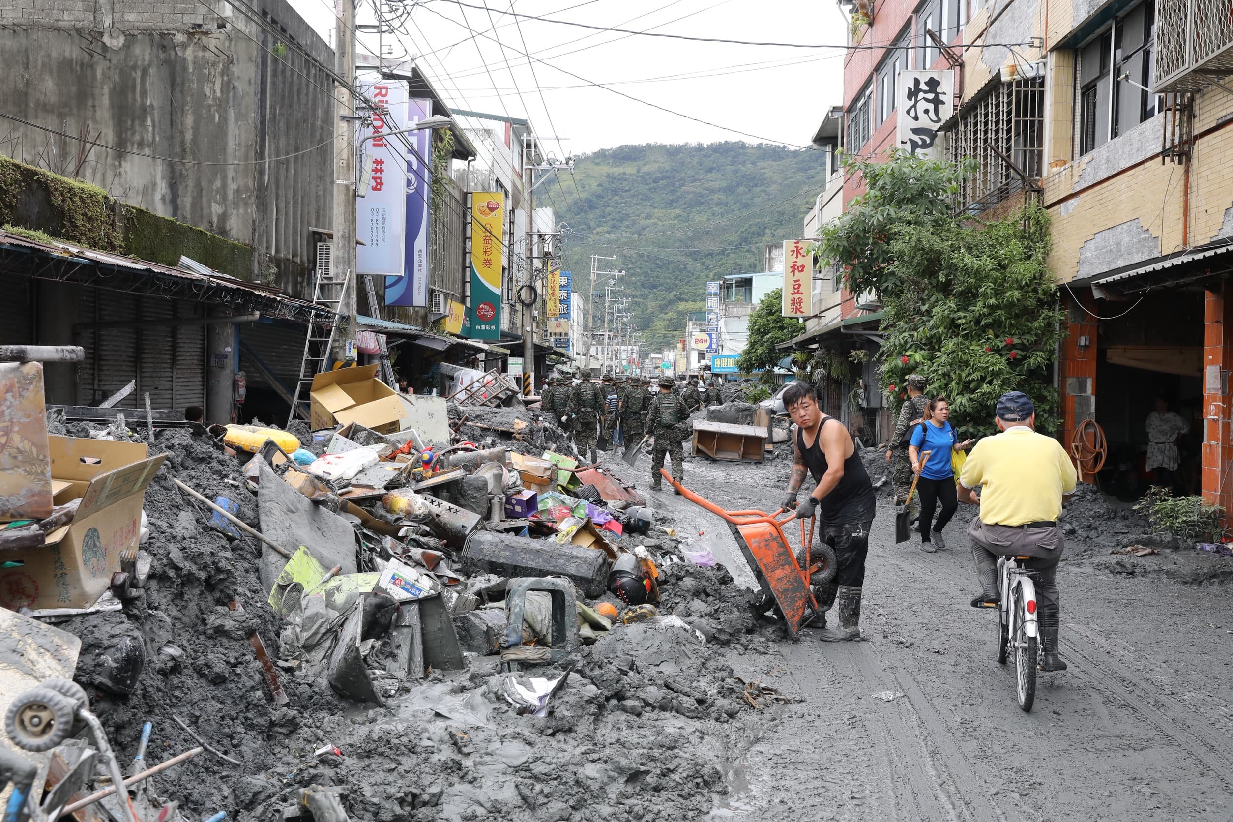 花蓮縣光復鄉街道仍有大量淤泥待清理,居民、國軍與志工齊心協力清理。