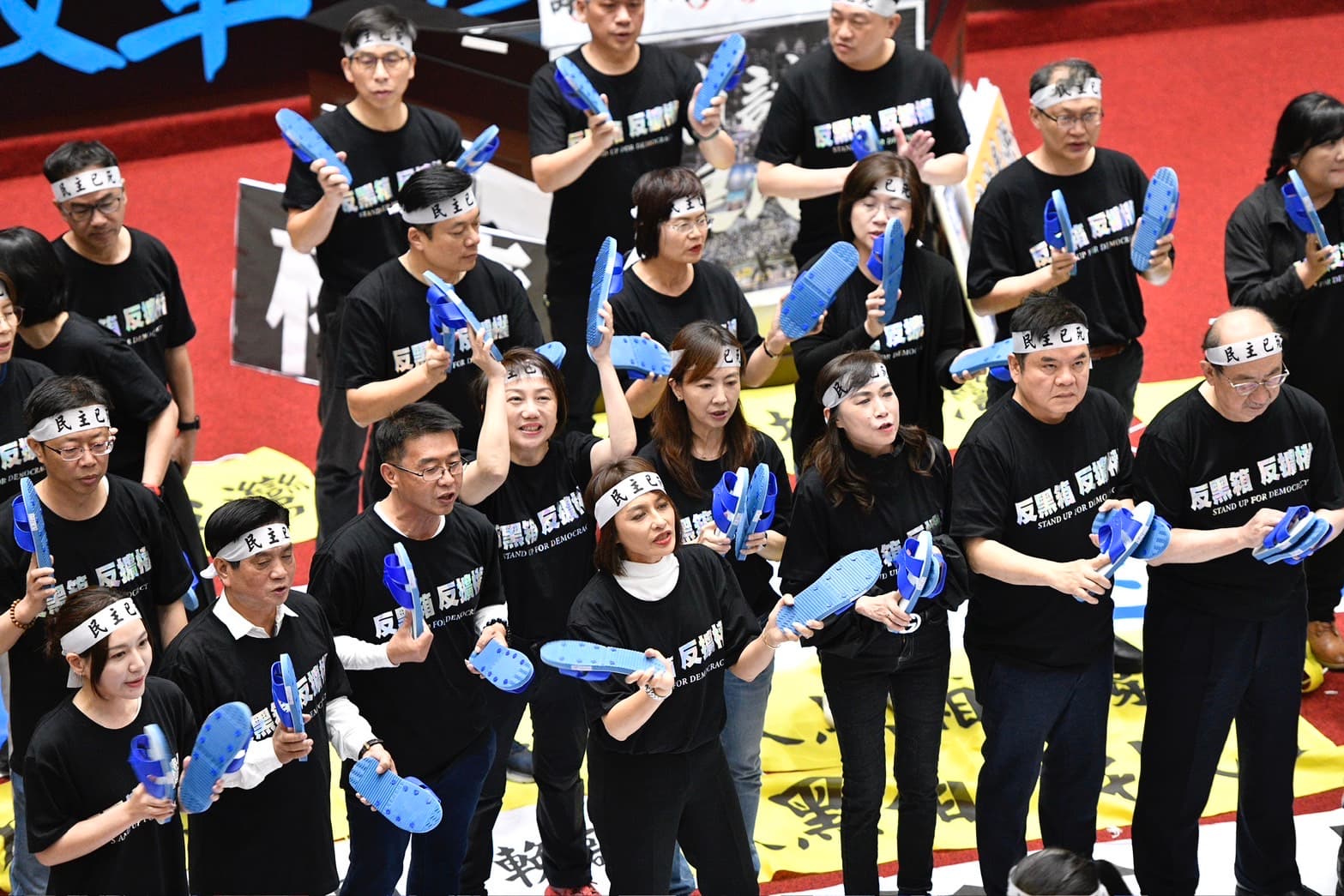 民進黨立委下午改走較溫和的方式抗爭,紛紛拿出「藍白拖」揶揄藍白兩黨。