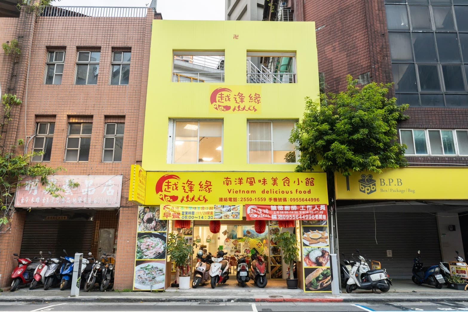 「越逢緣南洋風味美食小館」的亮黃色系外觀,在色彩低調的街道上十分搶眼。
