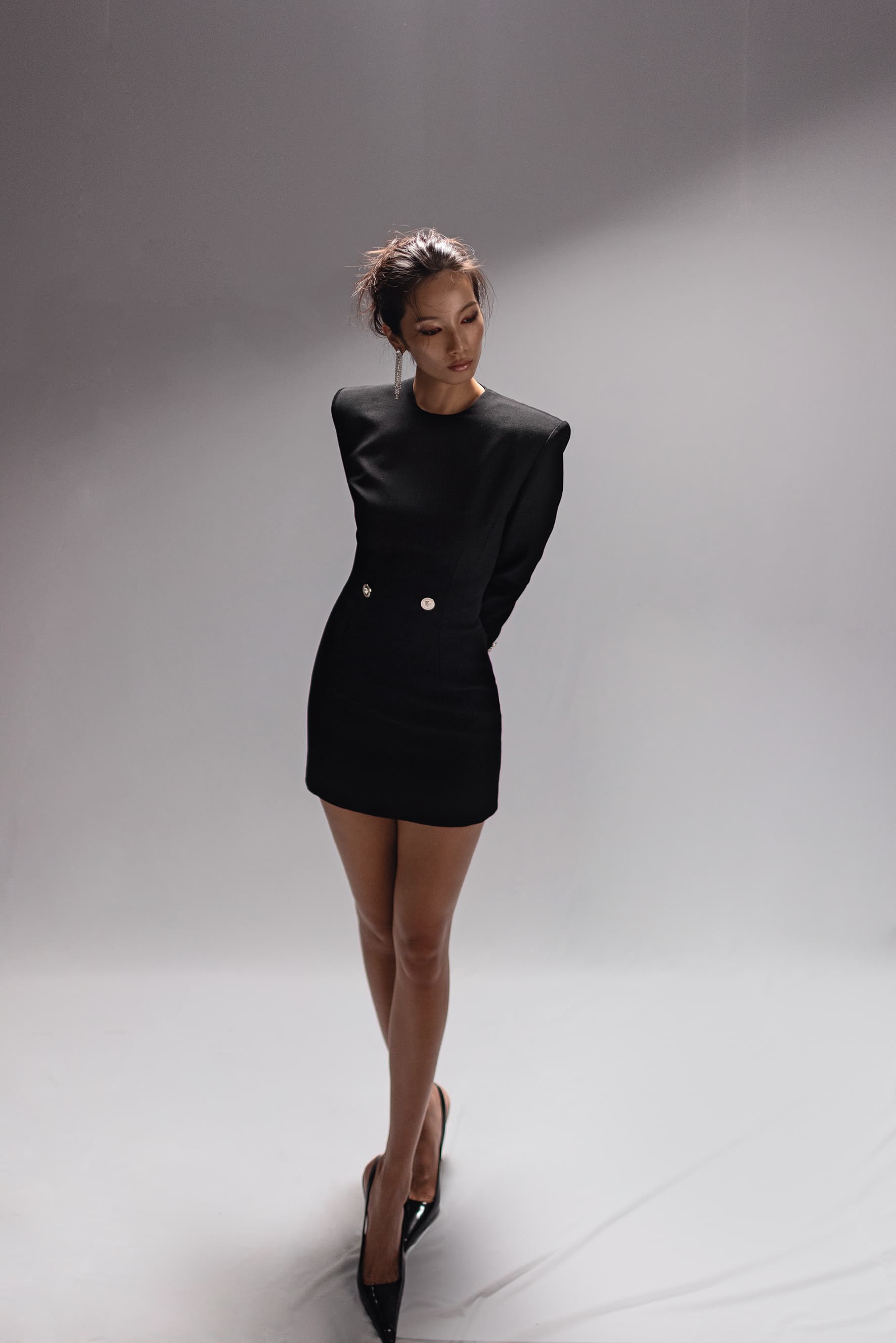黑色復古金釦洋裝，NT$103,000，by VERSACE；漆皮露跟高跟鞋，NT$41,000，by PRADA；銀色垂墜長耳環，NT$20,500，by Chloé。