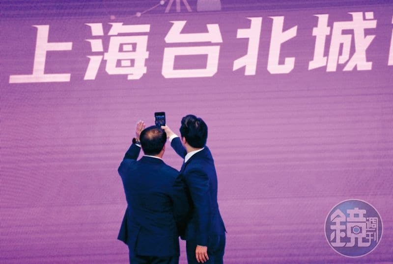 雙城論壇去年8月30日在上海舉辦,蔣萬安(右)在台上拿起手機拍照,留下紀念。(本刊資料照)