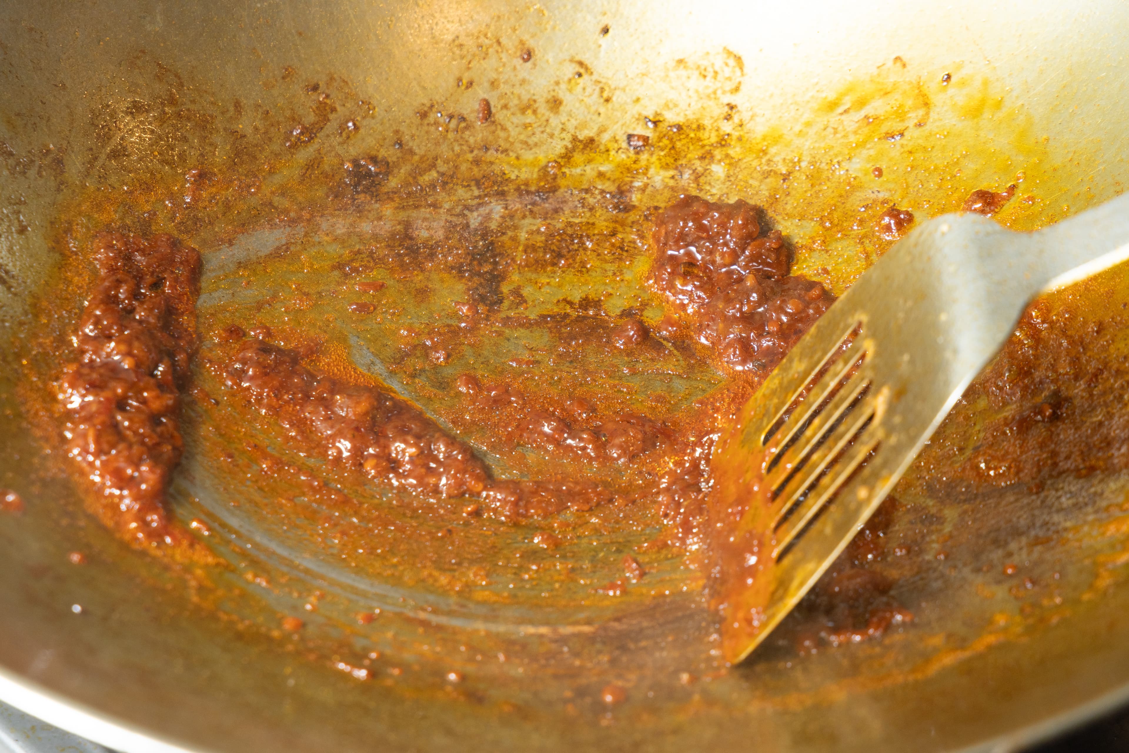 用鍋內原油爆炒一大瓢辣豆瓣醬。