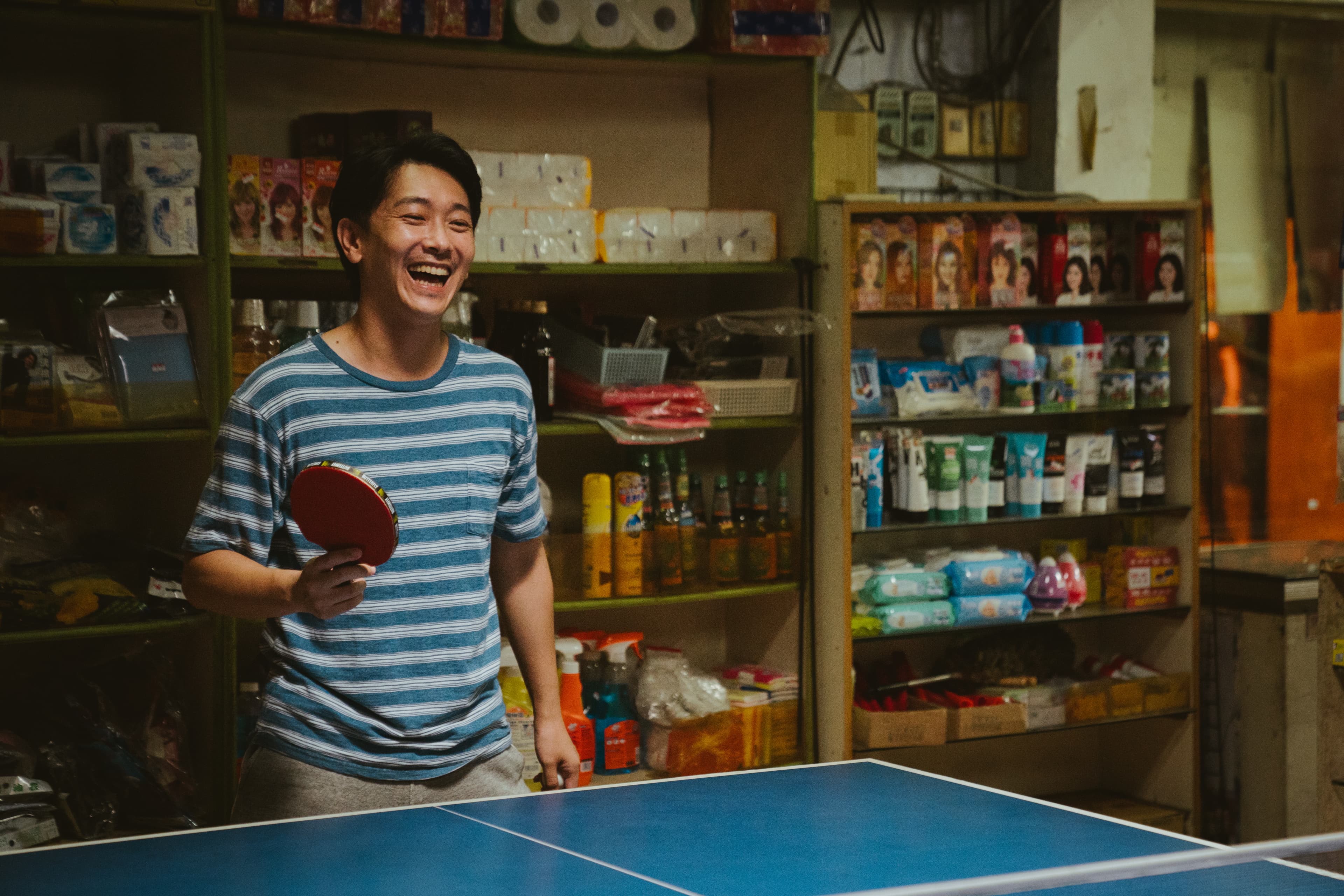 施名帥飾演家裡開雜貨店,看似平凡的前教練,意外接下國小桌球教練的任務,展開全新的挑戰。(華納兄弟提供)
