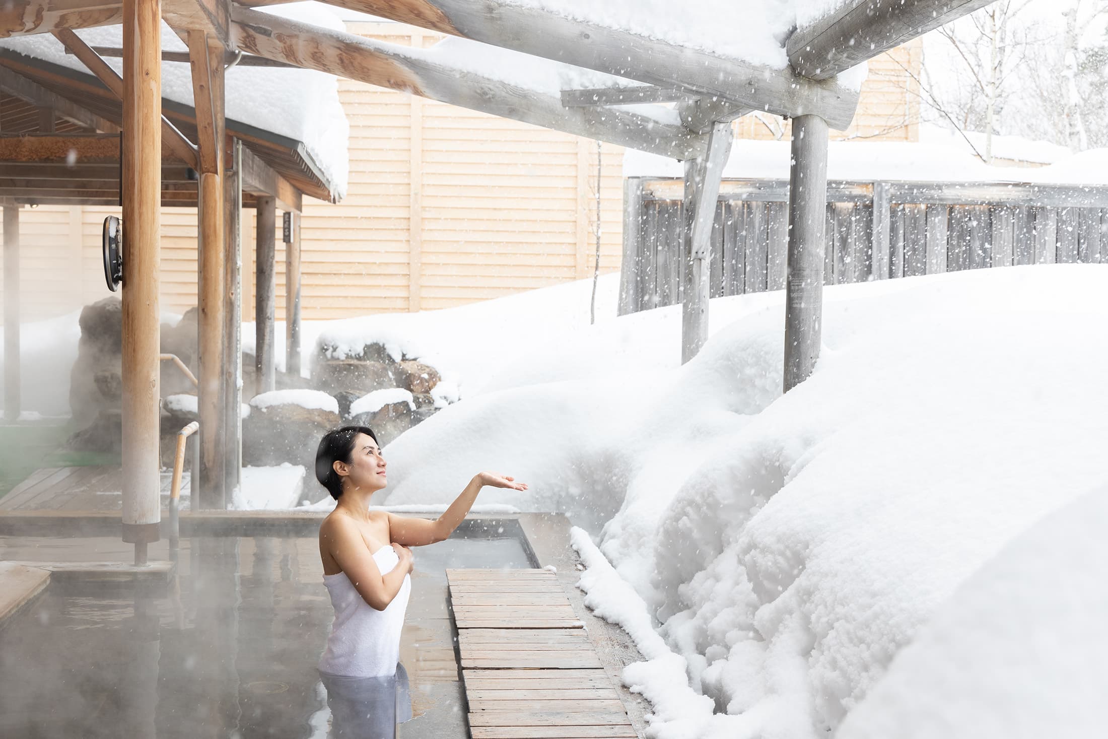 在「白樺之湯」享受露天溫泉的療癒感，看著眼前木造建築與白雪皚皚交織的夢幻景色，身心都得到滿足與放鬆。