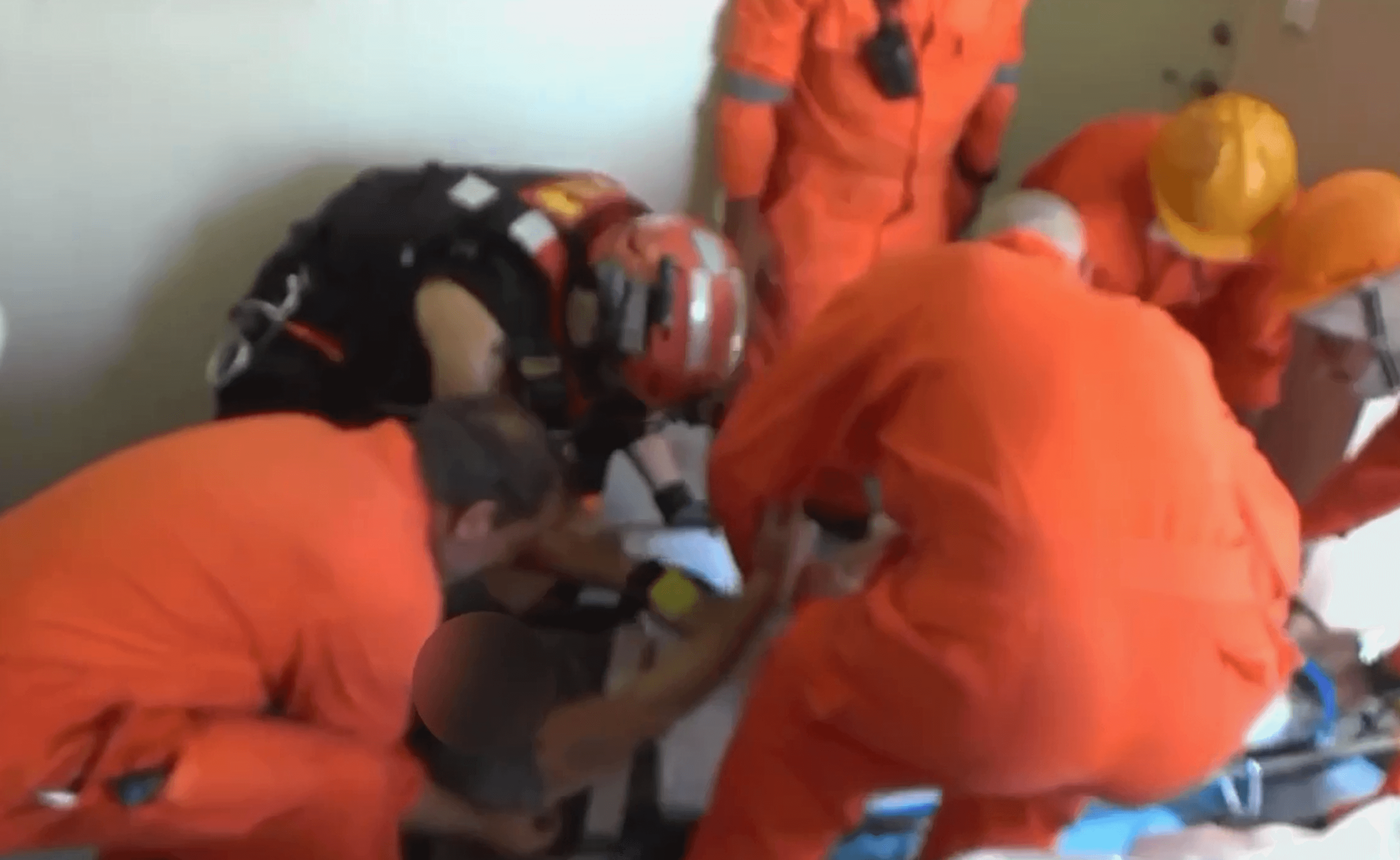 海巡搜救隊登船查看，發現2名船員手腳嚴重骨折，經固定患肢後，用擔架抬上直升機後送。（翻攝畫面）