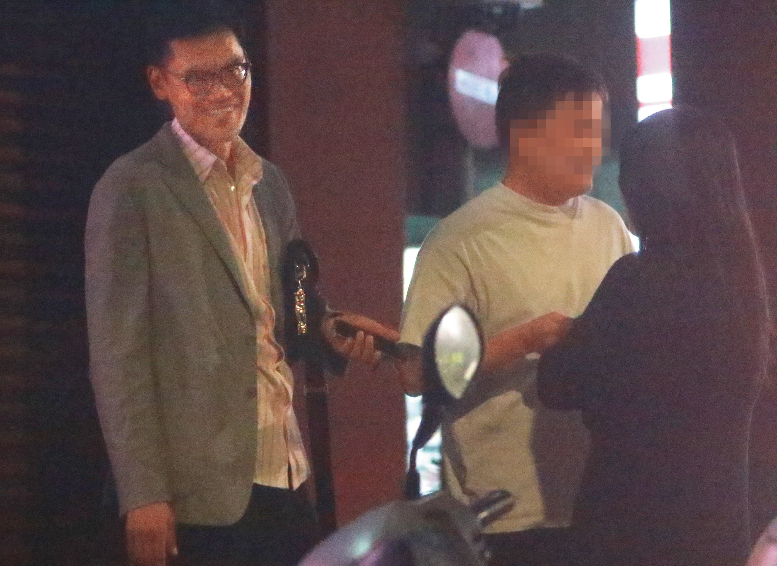 4/30,00:46,除了吳女的家,這天張軒銘(左)在自家社區前與一對男女談話,所在位置是台北文山區的別墅區大門。
