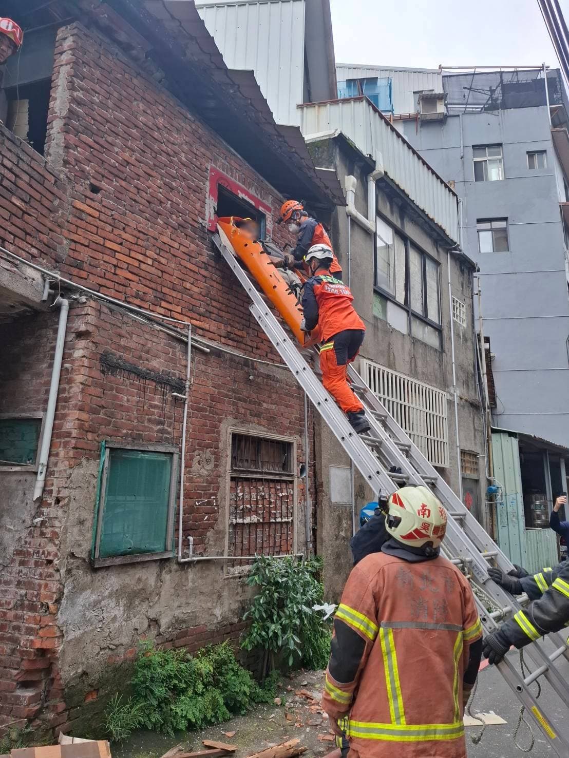 消防人員將受困40多歲的男子救出後,因胸部有擦挫傷,送往亞東醫院救治。(翻攝畫面)