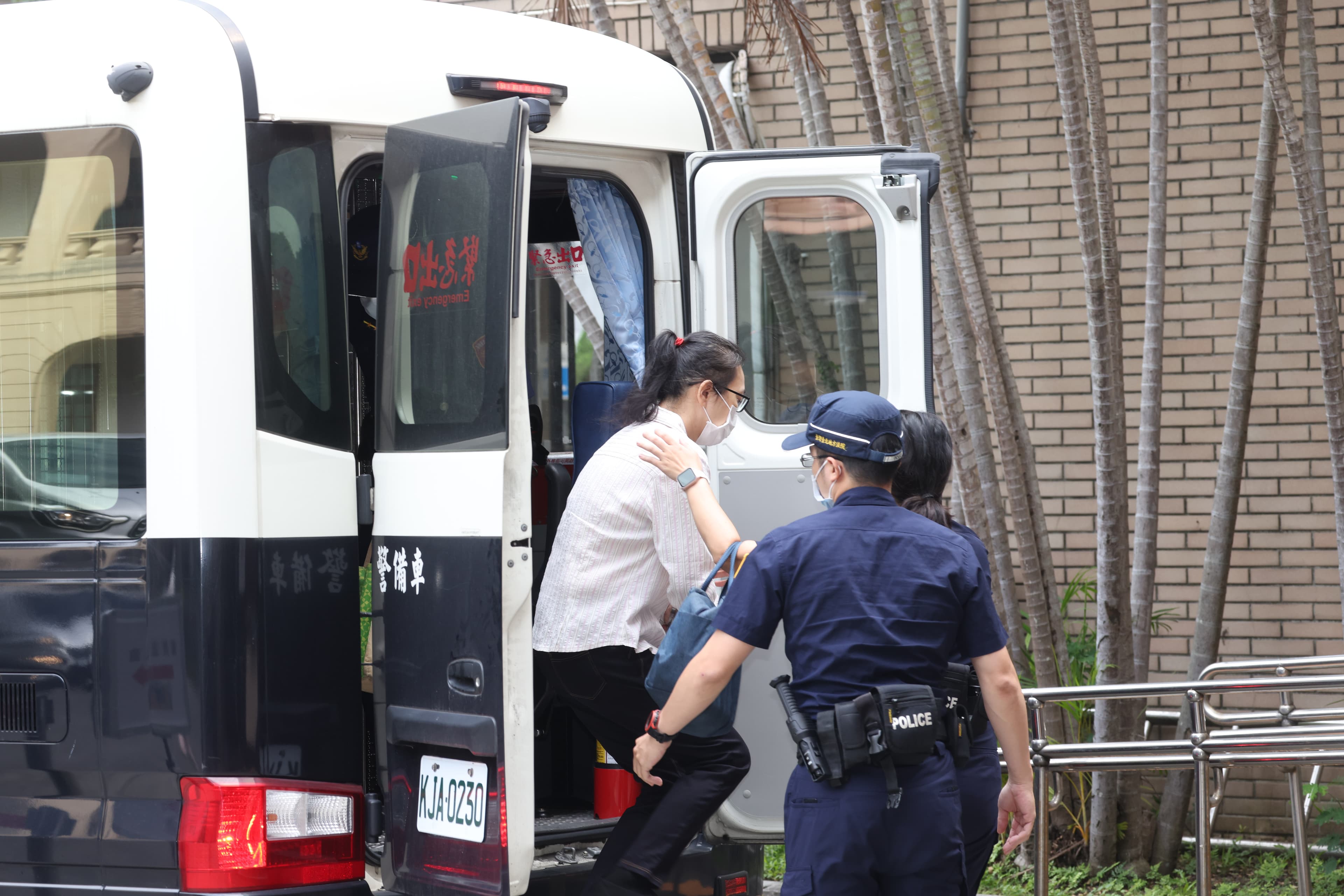 劉姓保母姊姊今日在法警戒護下抵達法院開庭。白衣者為劉姓姊姊。