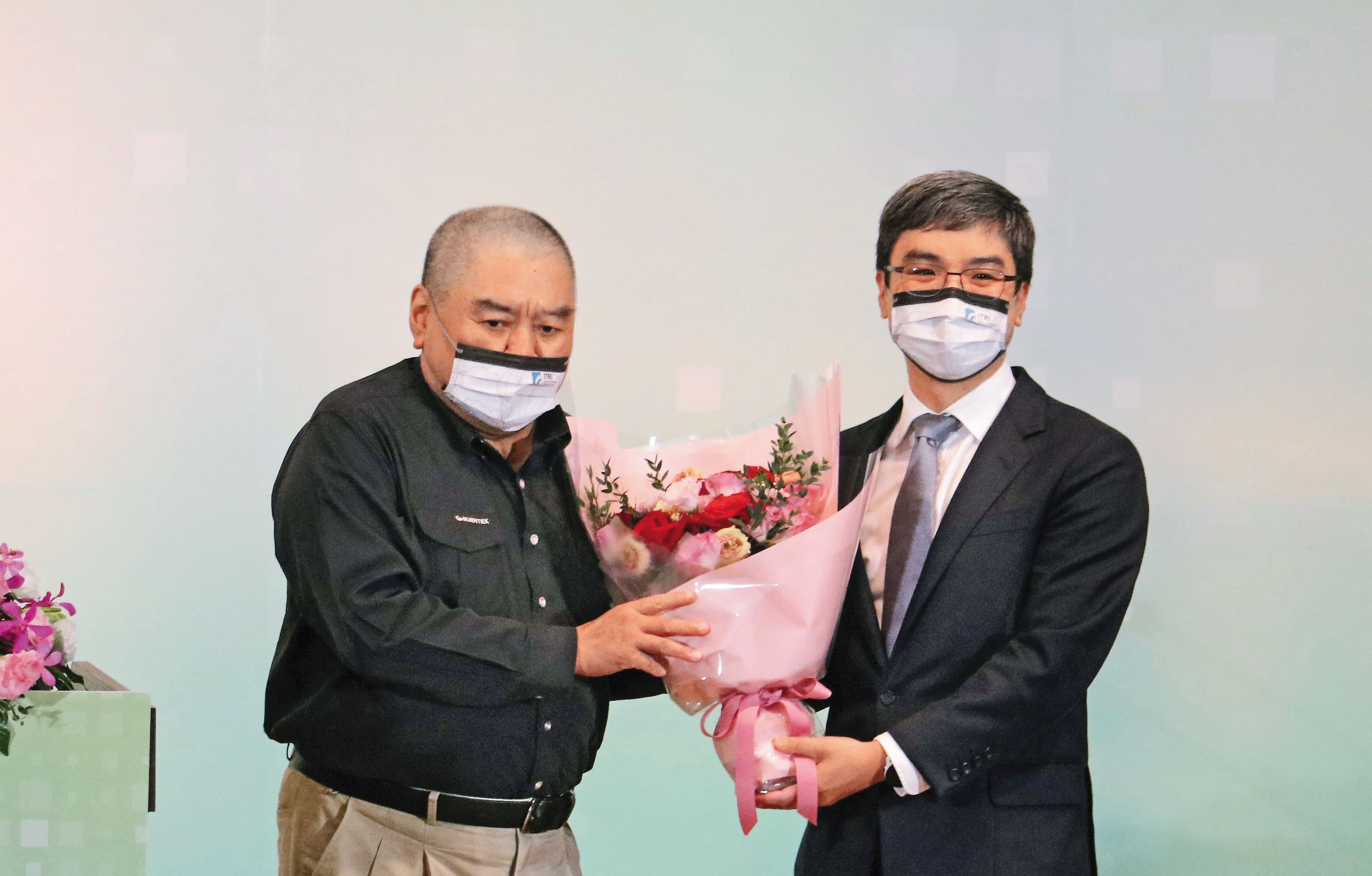尹衍樑(左)獲選為工研院院士,由任職南山人壽董事長的兒子尹崇堯(右)獻花致意。(唐獎教育基金會提供)