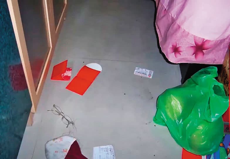 死者陳屍的套房內散落數個紅包袋,裡頭的鈔票都被抽走。(翻攝畫面)