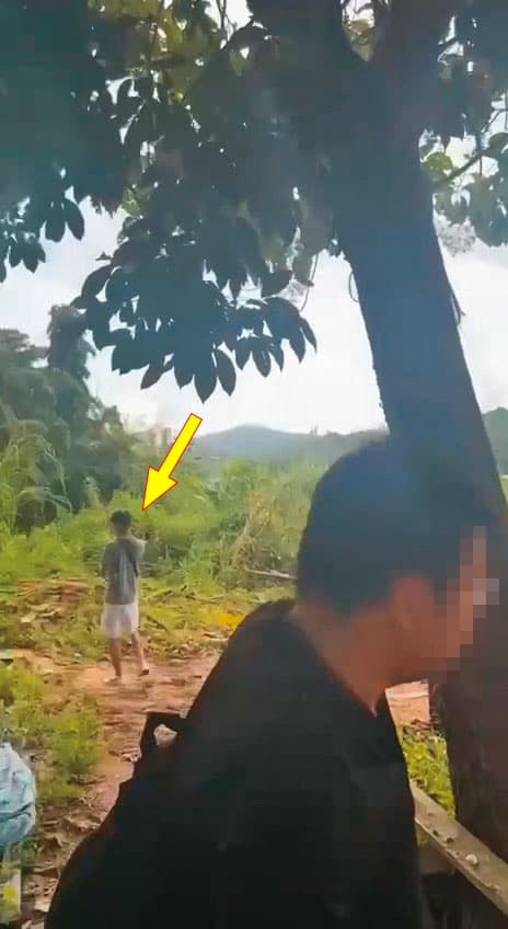 余男抵達泰國後,被載往偏僻山區,並在人蛇集團成員(箭頭處)監控下,被迫搭船偷渡到緬甸。(讀者提供)