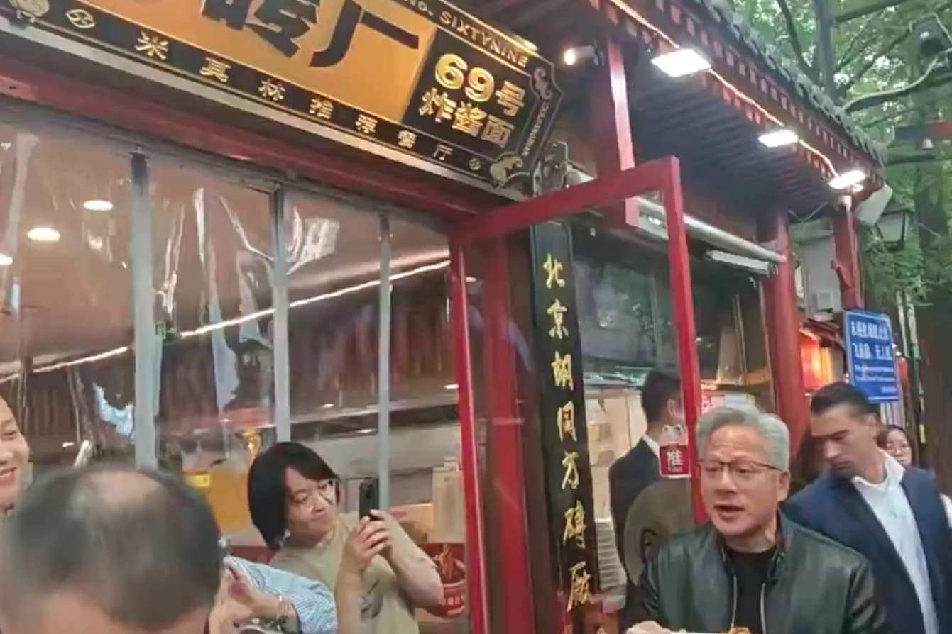 由於店內恰逢用餐尖峰時段、座無虛席，身價非凡的黃仁勳完全沒有架子，索性直接捧著大碗站在店門口大快朵頤。（翻攝自@0xScottlai X）
