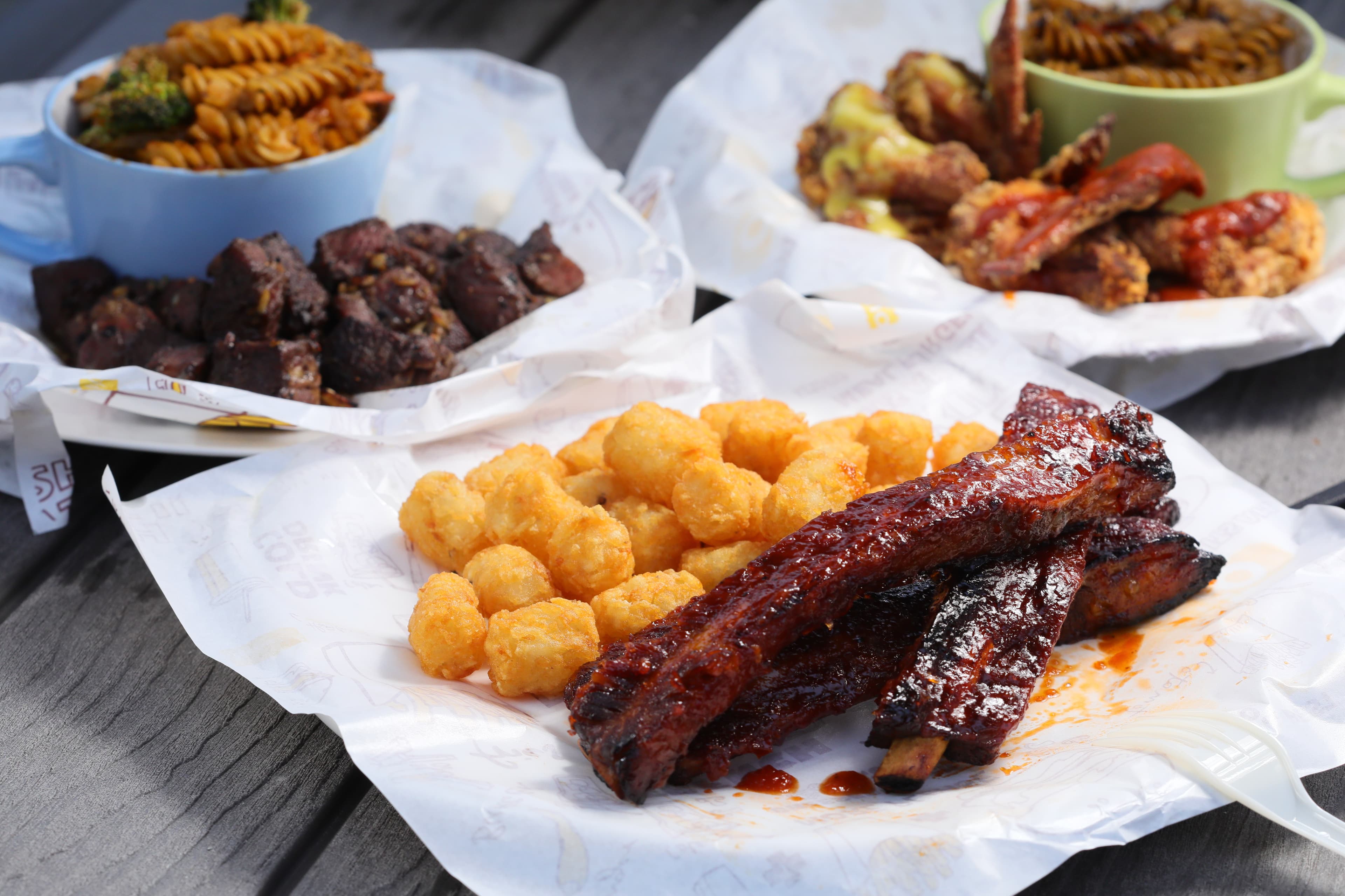 若多人出遊,可以選擇紅色穀倉的「BBQ美式煙燻烤豬肋排套餐」(前,380元/份)搭配「板腱牛排套餐」(左後,370元/份)或「風味雞翅」(右後,180元/份)一起分食。