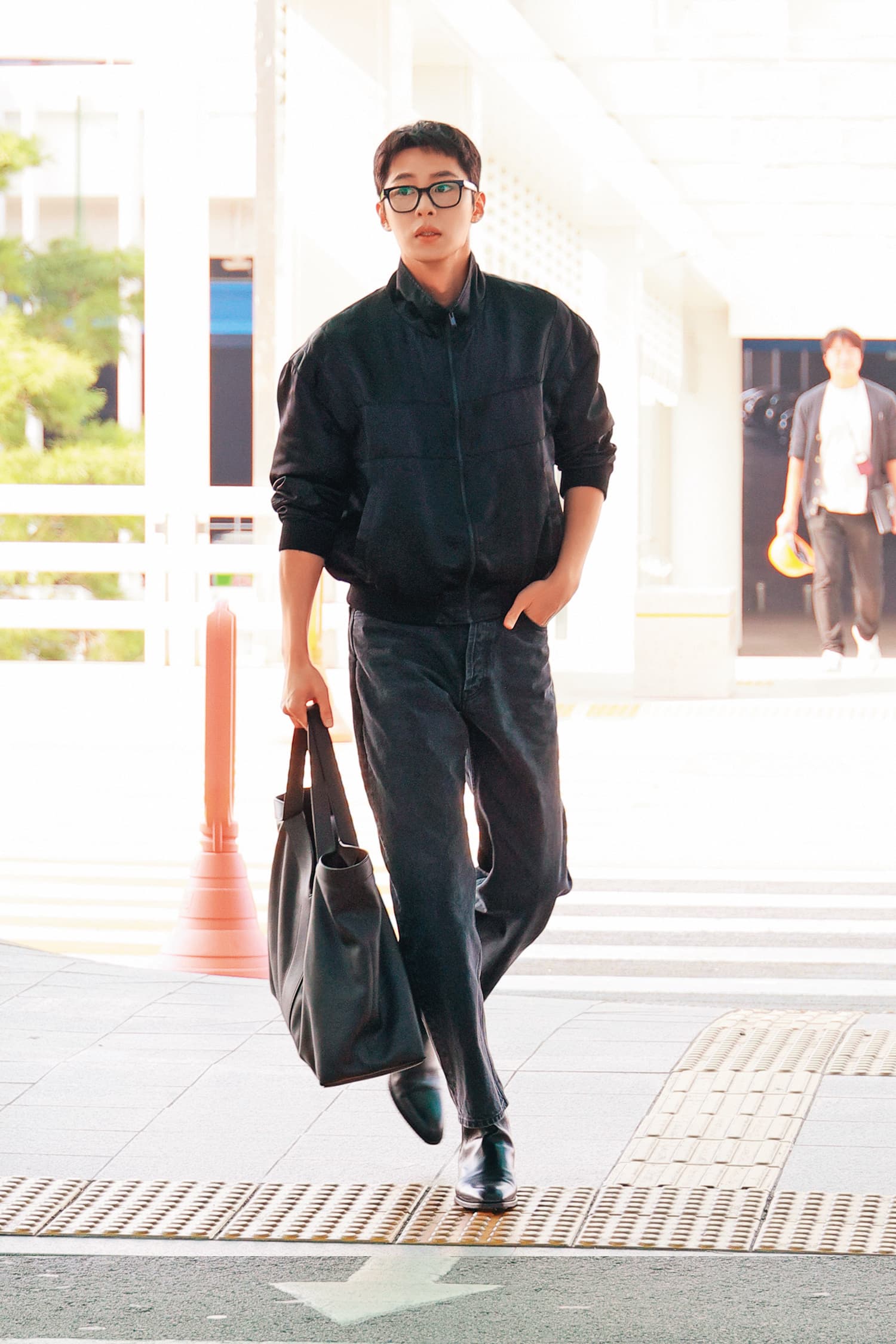 韓星李宰旭的機場穿搭,是緞面Teddy外套與仿舊黑色寬鬆牛仔褲搭配Y系列托特包,不經意中透露帥氣魅力。(Saint Laurent提供)