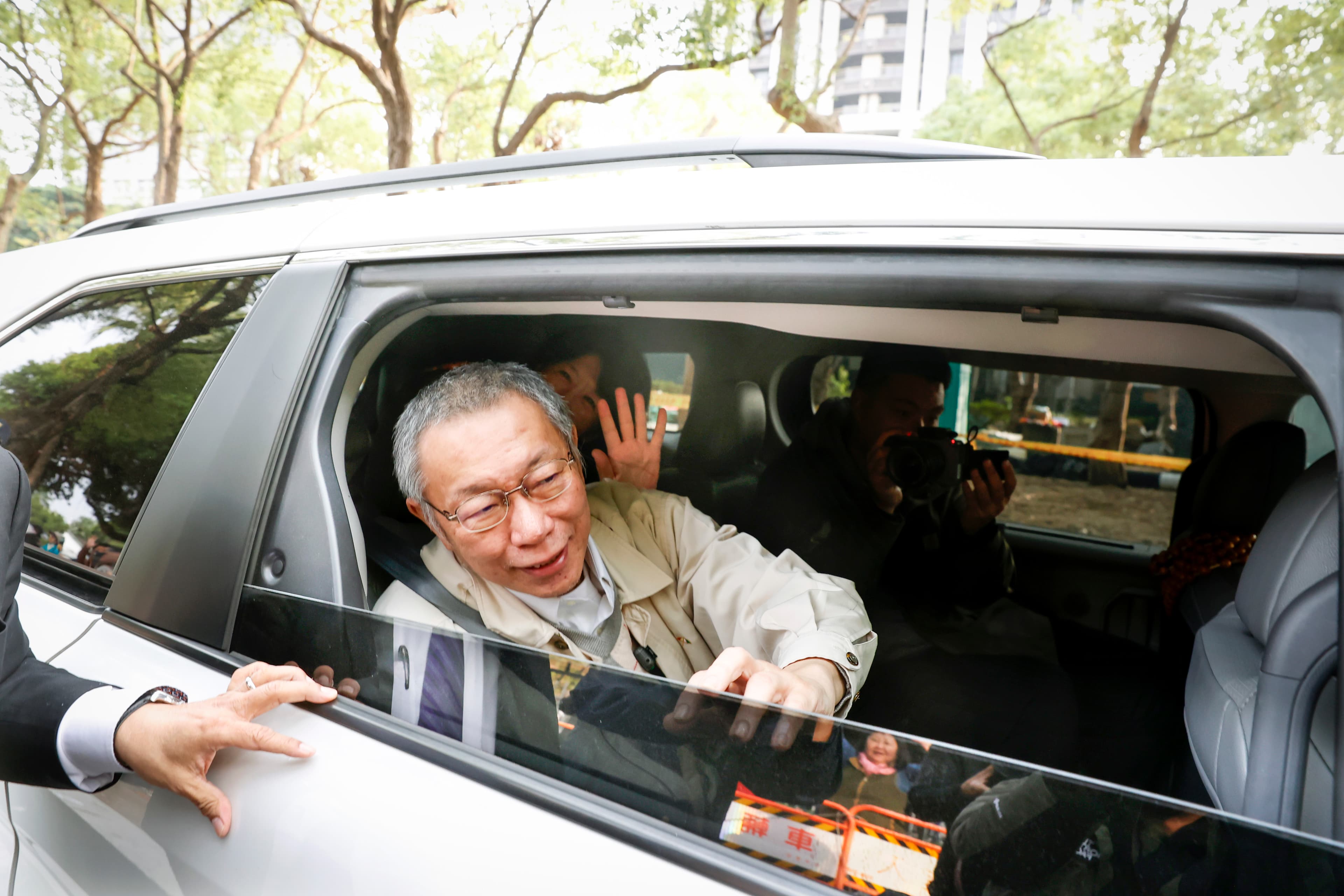柯文哲座車放慢速度,搖下車窗讓柯能跟小草揮手致意。