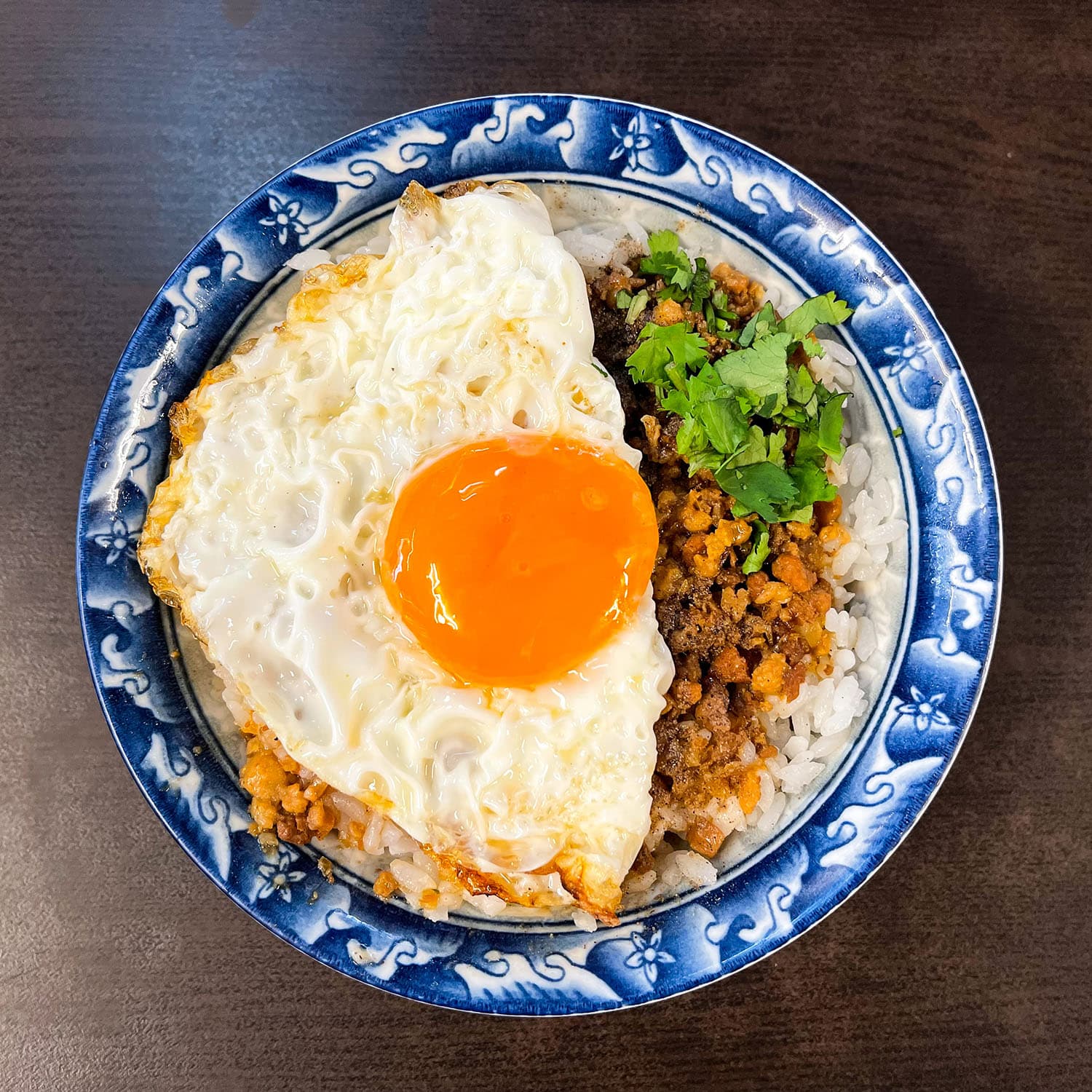 「秀明豬心冬粉」的「月見肉燥飯」很受歡迎,肉燥純以瘦肉熬煮,有別於其他作法,配上油亮的半熟煎蛋,絲滑的蛋液混合鹹香米飯,令人回味無窮。(Michelin提供)