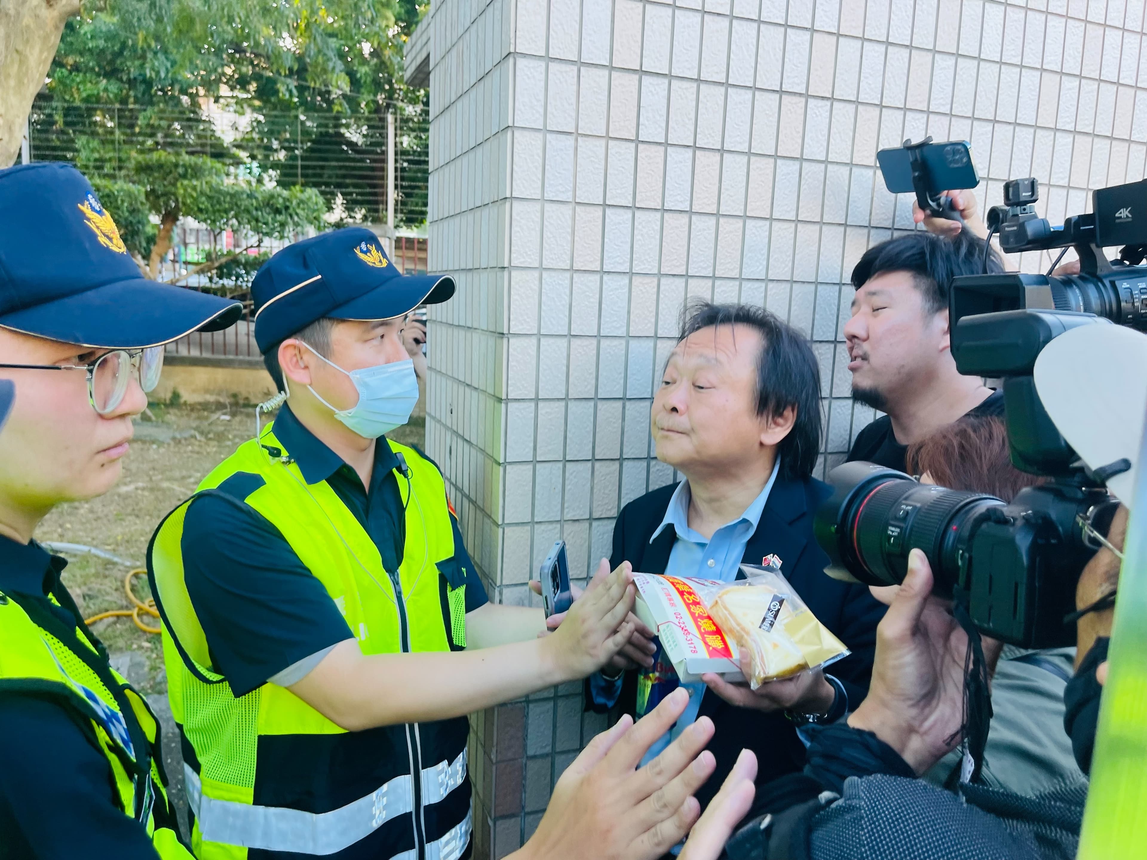 王世堅手持雞鴨便當、起酥蛋糕。