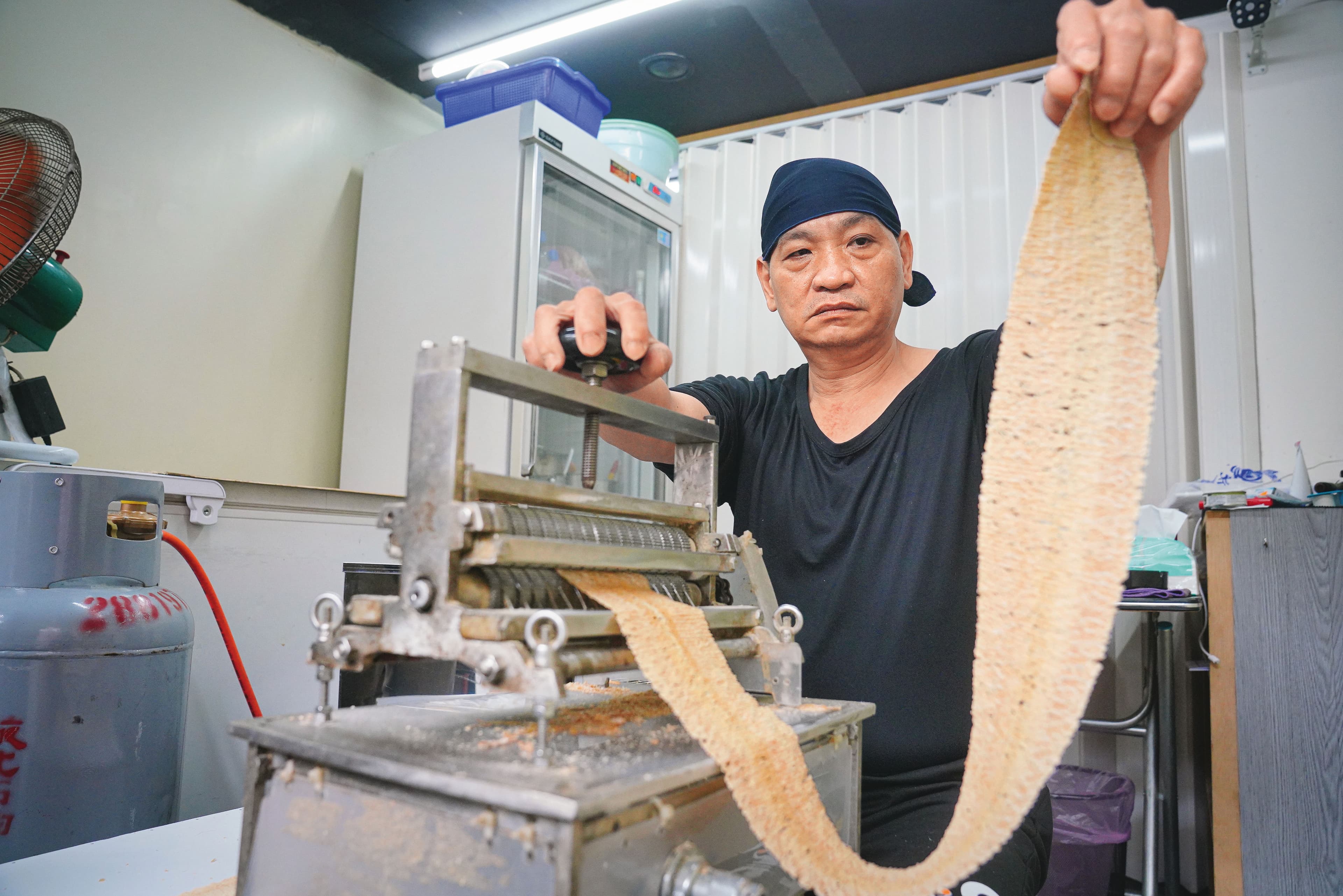 每隻魷魚只能壓成2片魷魚片,目前都由阿嬌姨的乾兒子小胖在開店前處理,雖以機器壓製,仍得靠手感微調,才能壓得均勻。